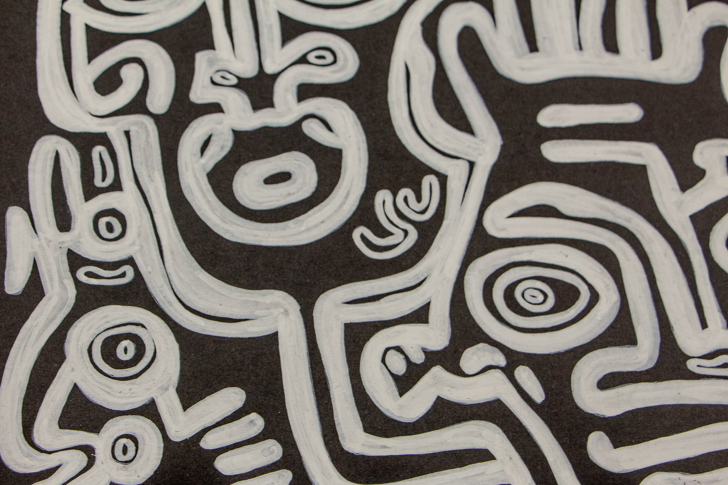 Turbulent Aegis 003 detail: close-up of interwoven abstract faces and symbols in white on dark wood, highlighting the layered linework, rounded facial forms, and the dense emotional web of the composition.