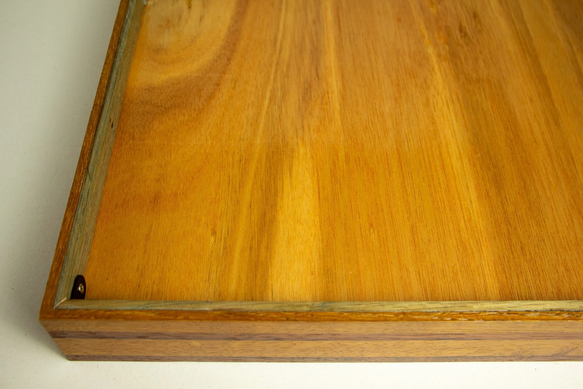 Unseen Signifiers 002 frame detail: back view of the frame showing the warm-toned wooden back panel, inner retaining edge, and black corner bracket securing the construction.