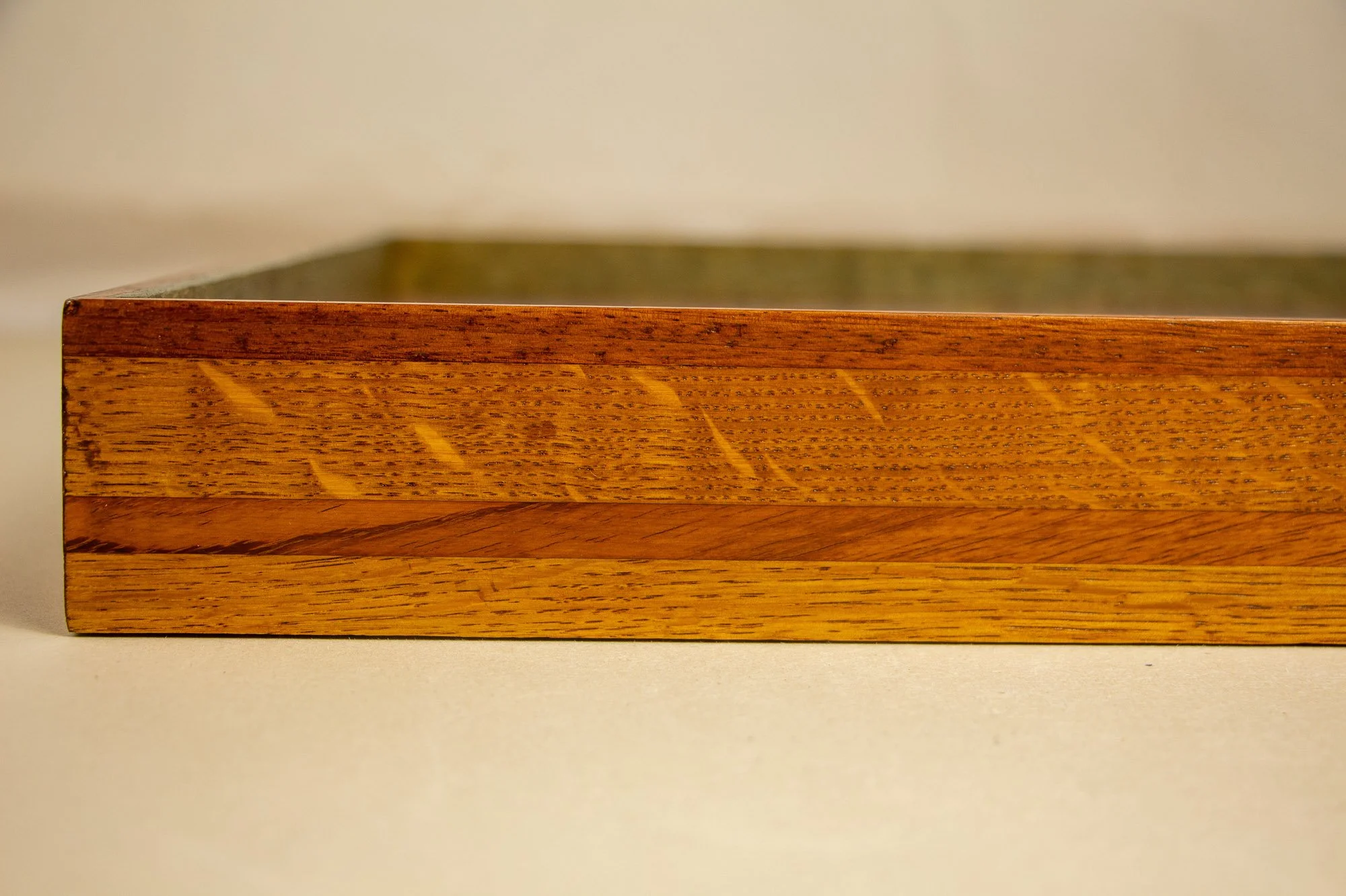 Unseen Signifiers 006 frame detail: straight-on close-up of the frame side, featuring the broad golden wood surface intersected by a darker diagonal stripe and capped by a thin reddish-brown top band. mahogany, oak and beech wood.