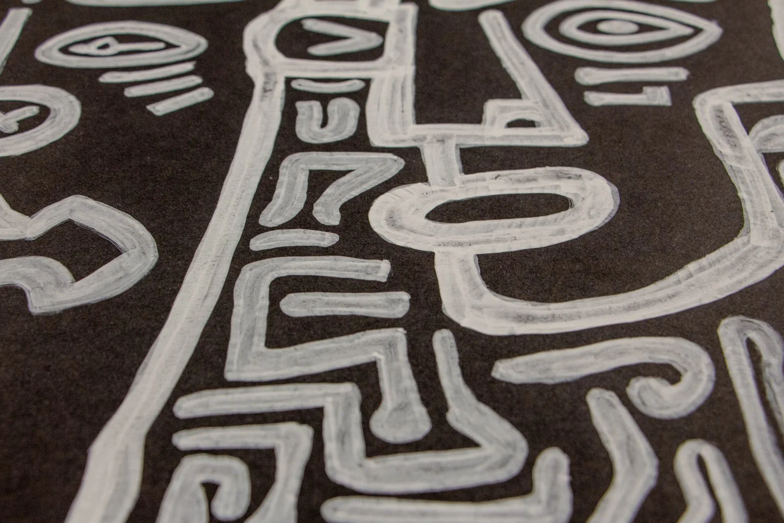 Metamorphic Entwining 002 detail: totem-like vertical face with oval mouth and stacked glyphs, maze of bends and turns, white ink on black paper