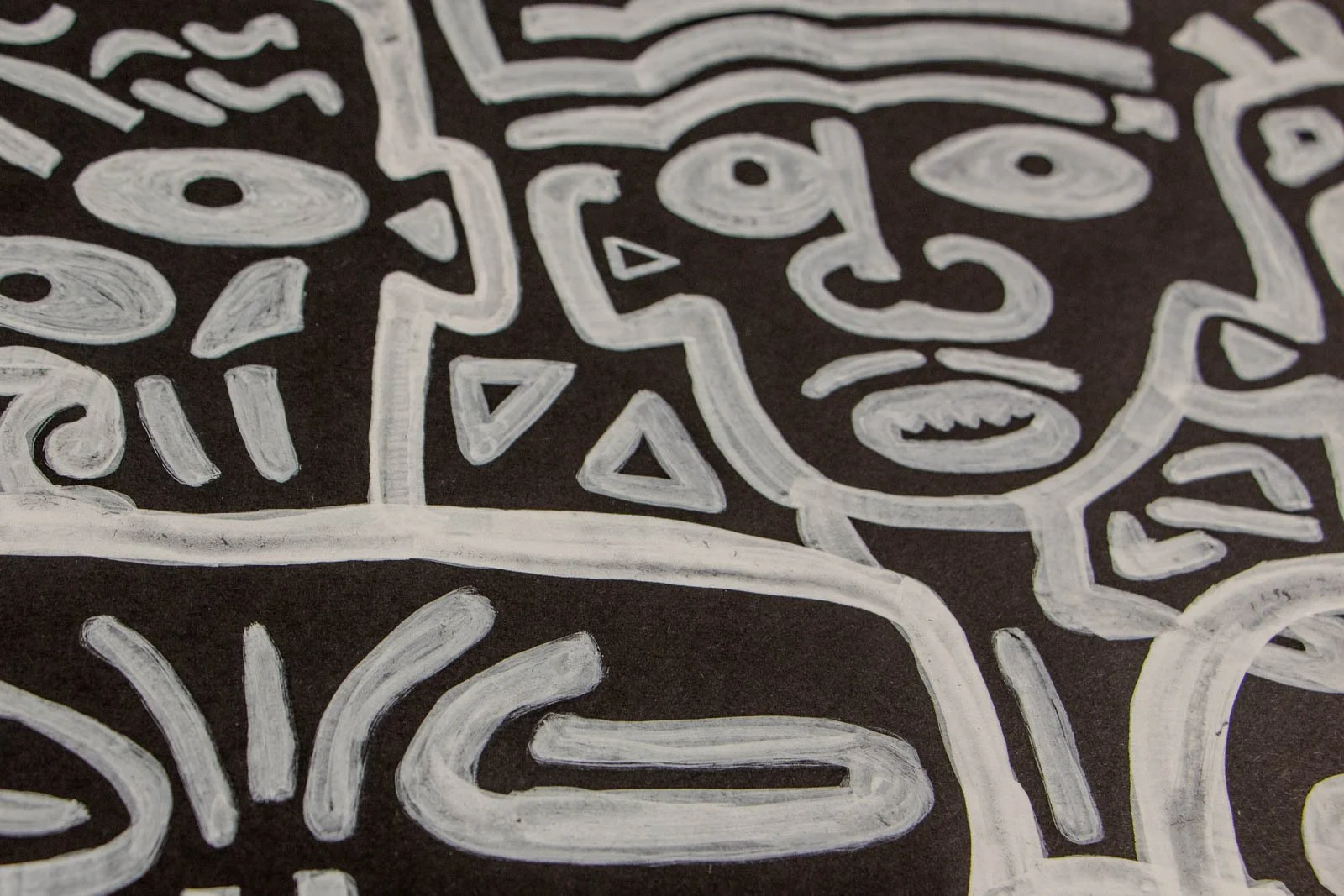 Metamorphic Entwining 002 detail: face with banded hairlines and triangle cluster at the neck, dotted accents and sweeping cheek marks, white ink on black paper