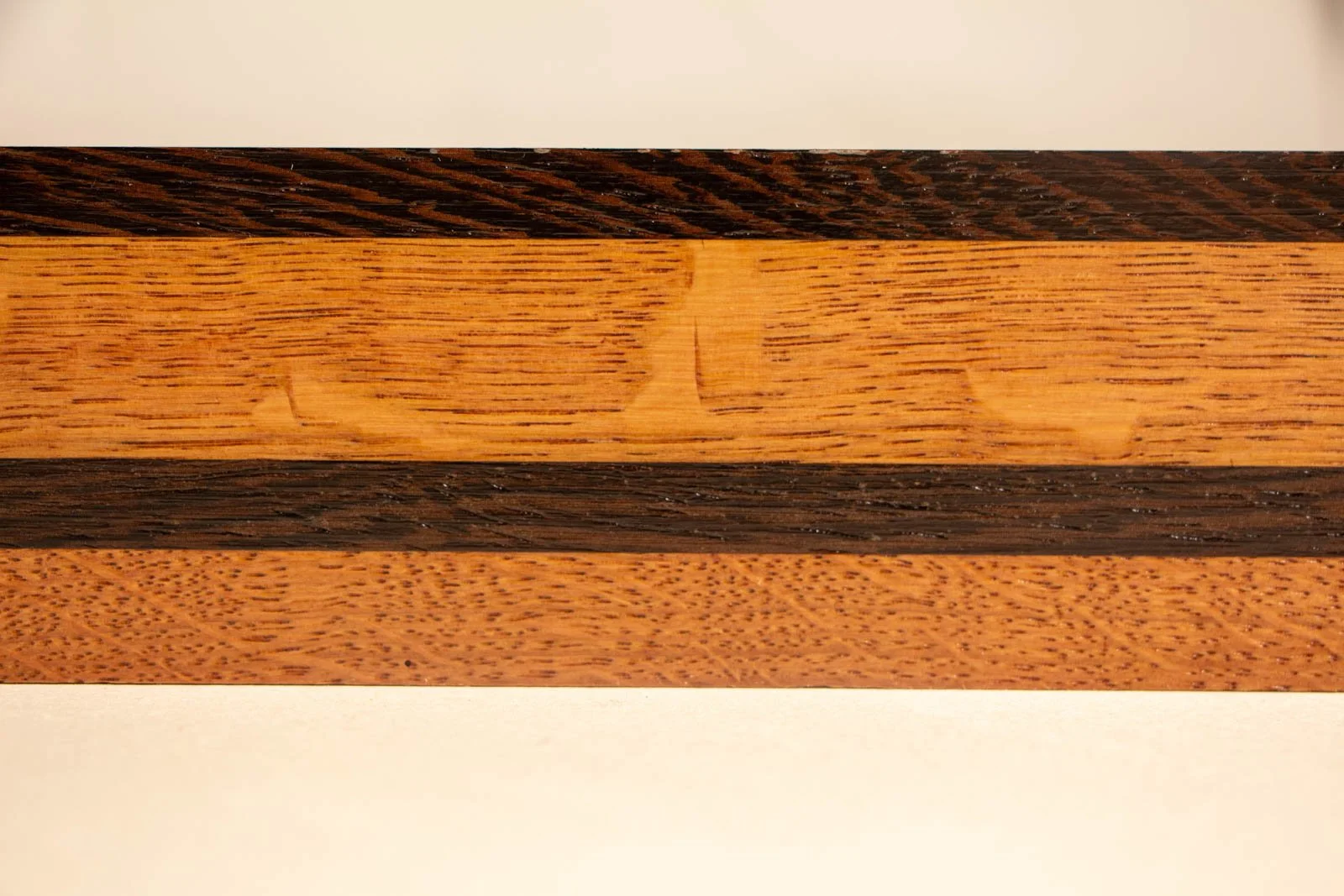 Formless Equation 003 frame: straight-on view of oak grain with central wengé inlay strip, crisp profile lines