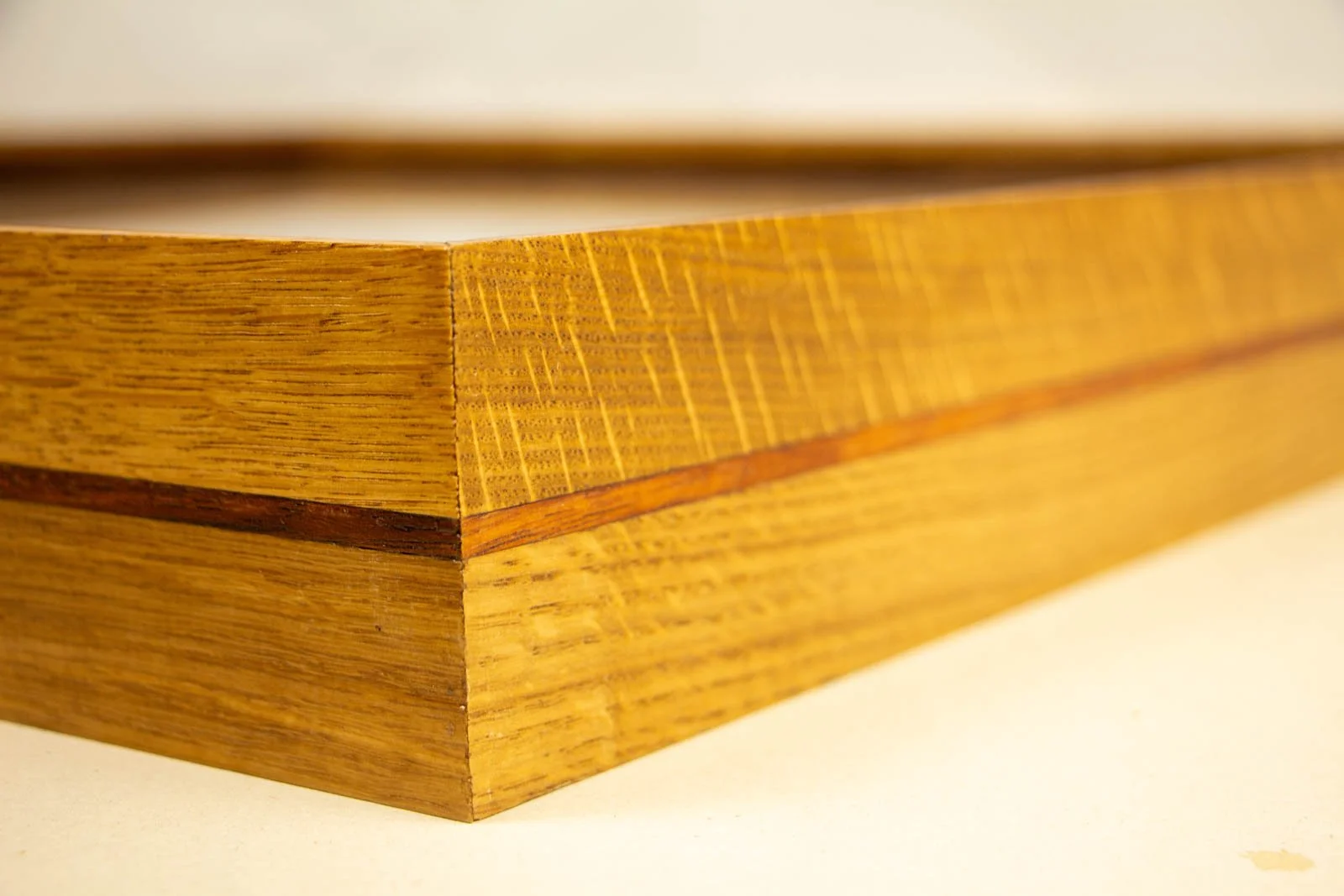 Golden Nostalgia 001 frame: outer corner, broad quarter-sawn oak body with a fine centered mahogany pinstripe; smooth satin sheen