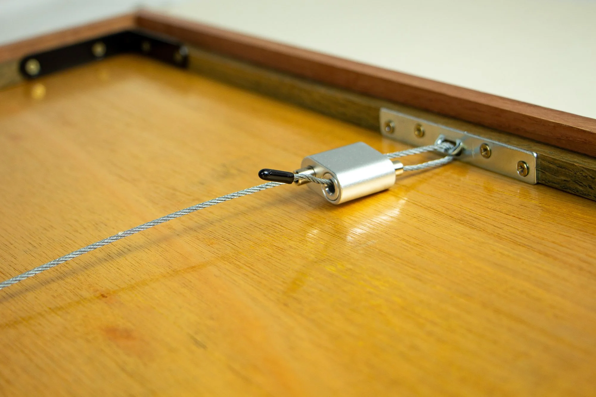 Resonant Syntax 001 frame: reverse detail of the hanging system, with steel cable, silver locking mechanism, metal mounting plate, meranti plywood back panel, and layered mahogany-and-oak frame construction