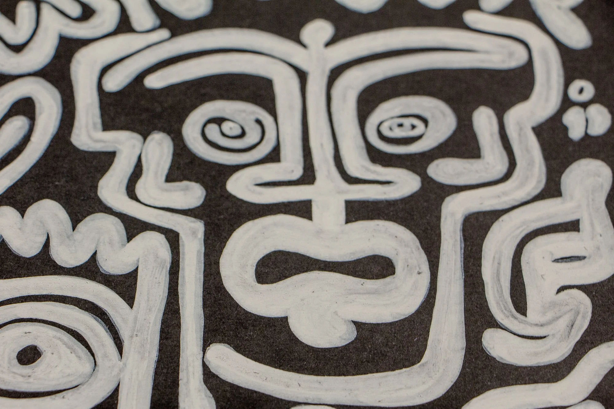 Turbulent Aegis 001 artwork detail: frontal close-up of a stylized white-lined face with spiral eyes and an infinity-shaped mouth, emphasizing stillness held inside turbulence.