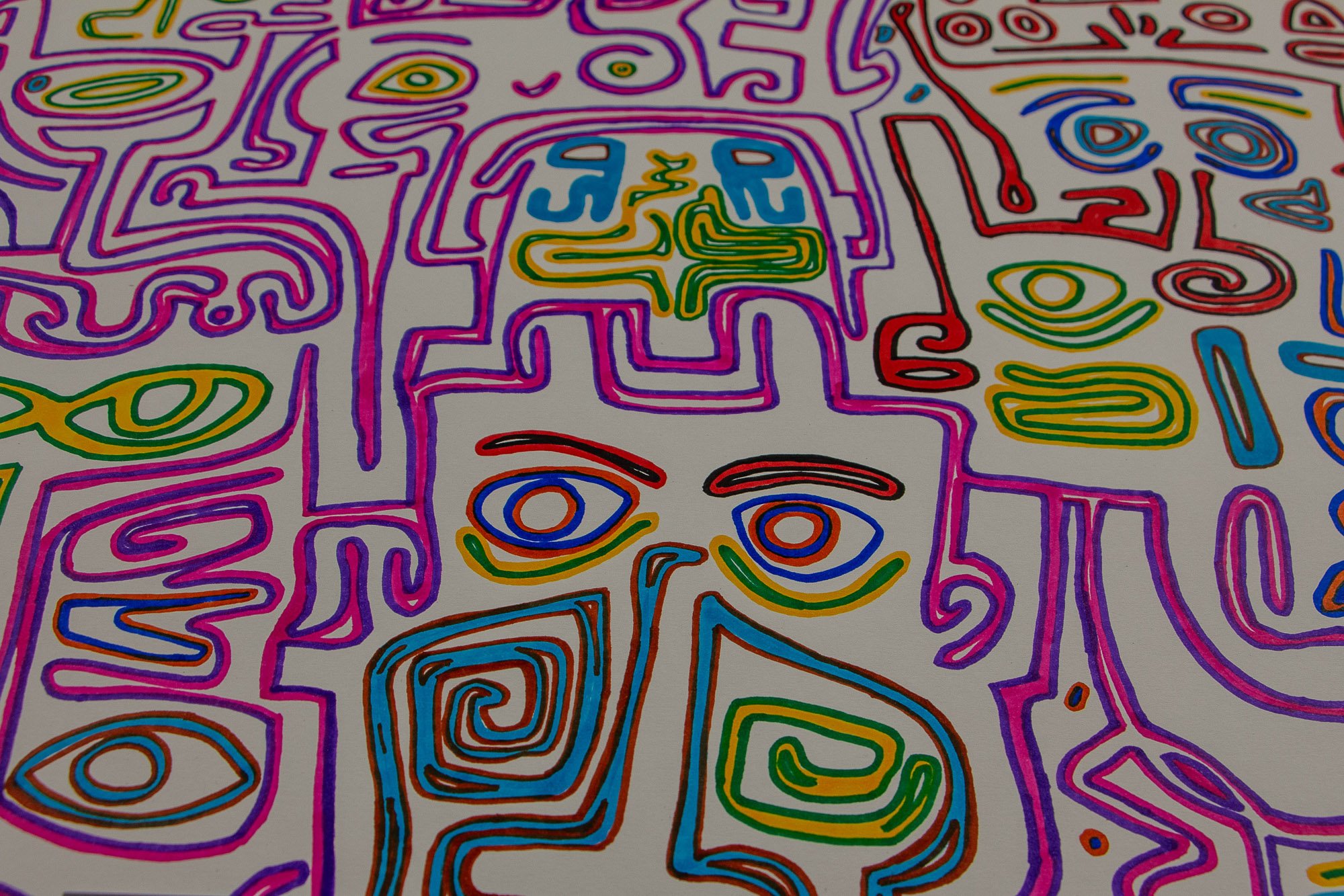 Eclipsing Gravitas 003 detail: close-up of a face-like figure outlined in pink and violet, with blue-ringed eyes, spiral cheek forms, and surrounding geometric and curving motifs in green, blue, red, and yellow on white paper.