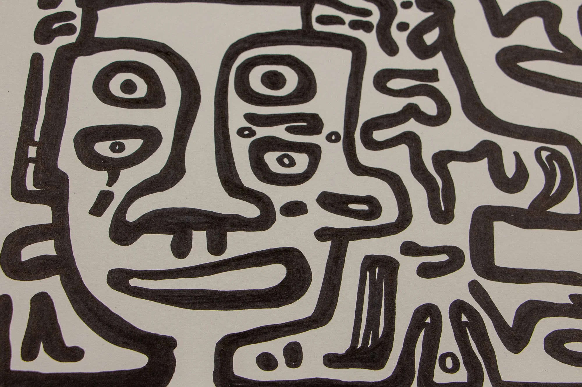 Veiled Alchemist 003 detail: close-up of a mask-like face with stacked eyes and a broad mouth, framed by bold contours and neighboring abstract elements that press closely around the figure.