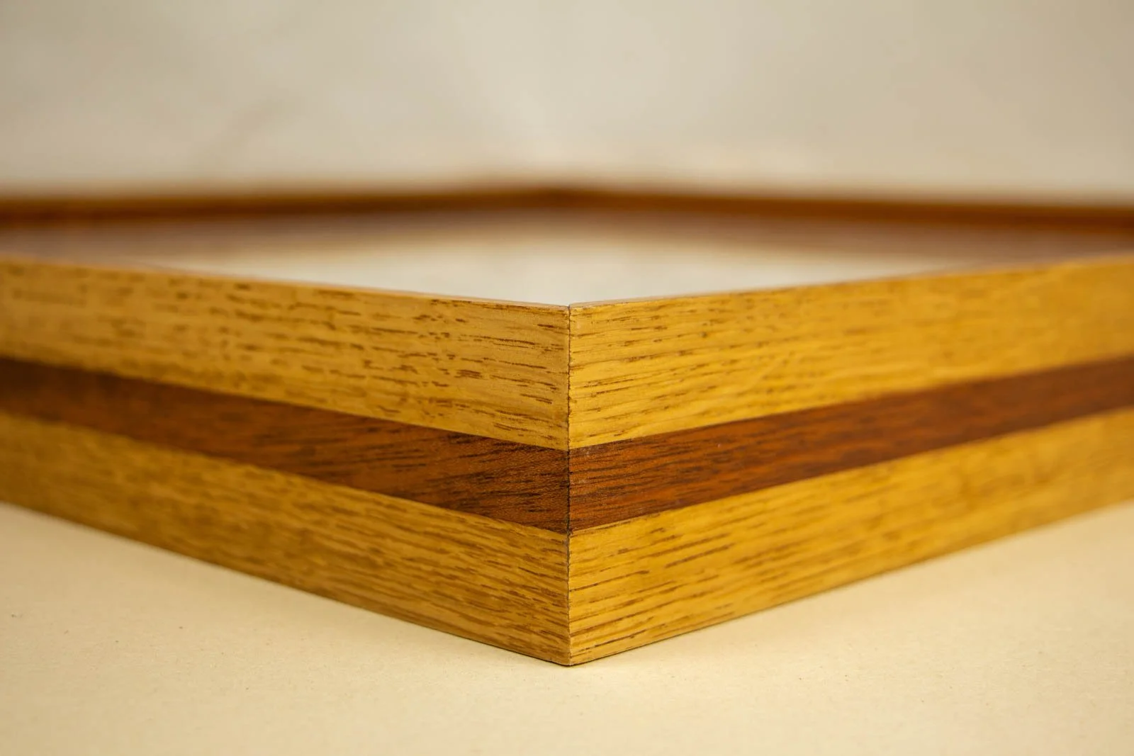 Golden Nostalgia 002 frame: mitered corner, honey oak rail with a centered mahogany band; clean join, satin finish