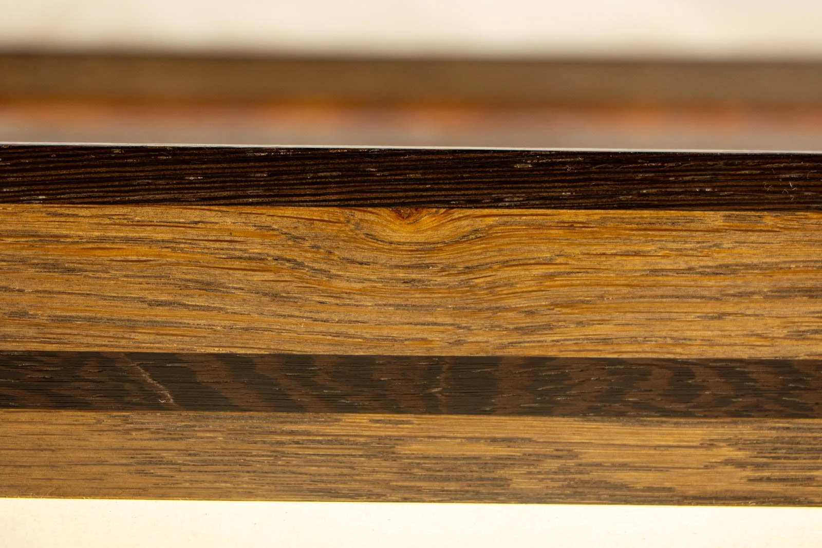 Synaptic Mythos 003 frame: profile along the long side, lean section; uninterrupted wengé stripe running true down the rail