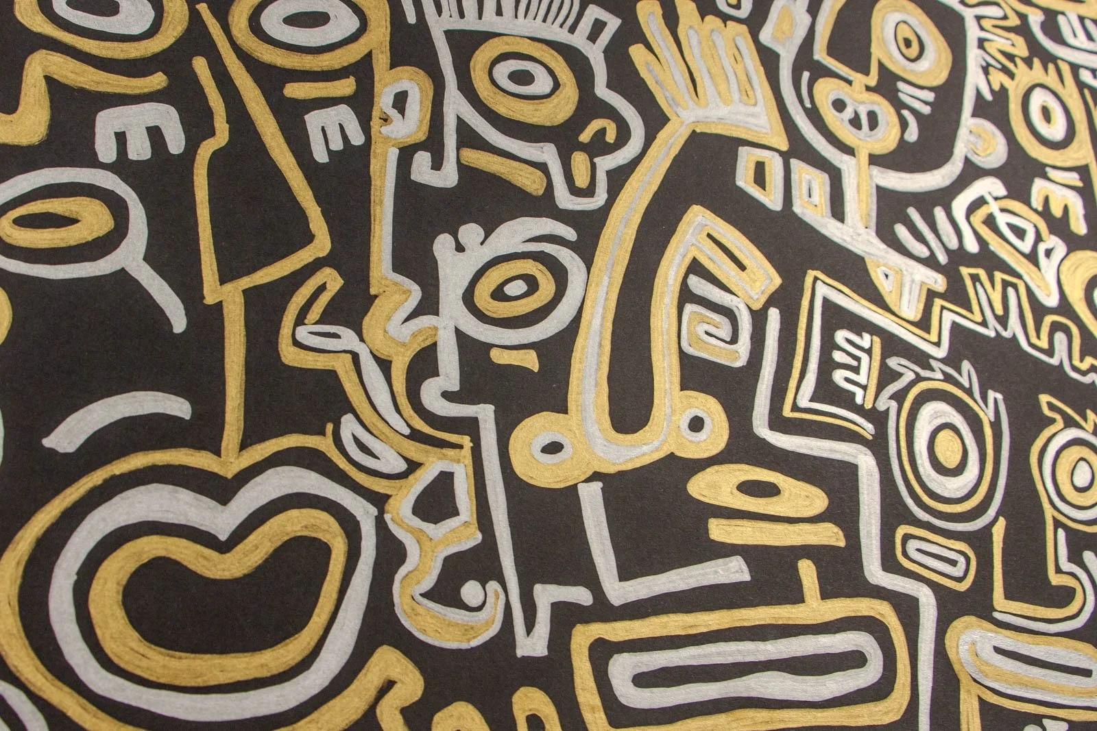 Golden Nostalgia 001 detail: low raking macro, metallic gold and silver glyphs on matte black; heart motif and profiles shimmering along pooled edges