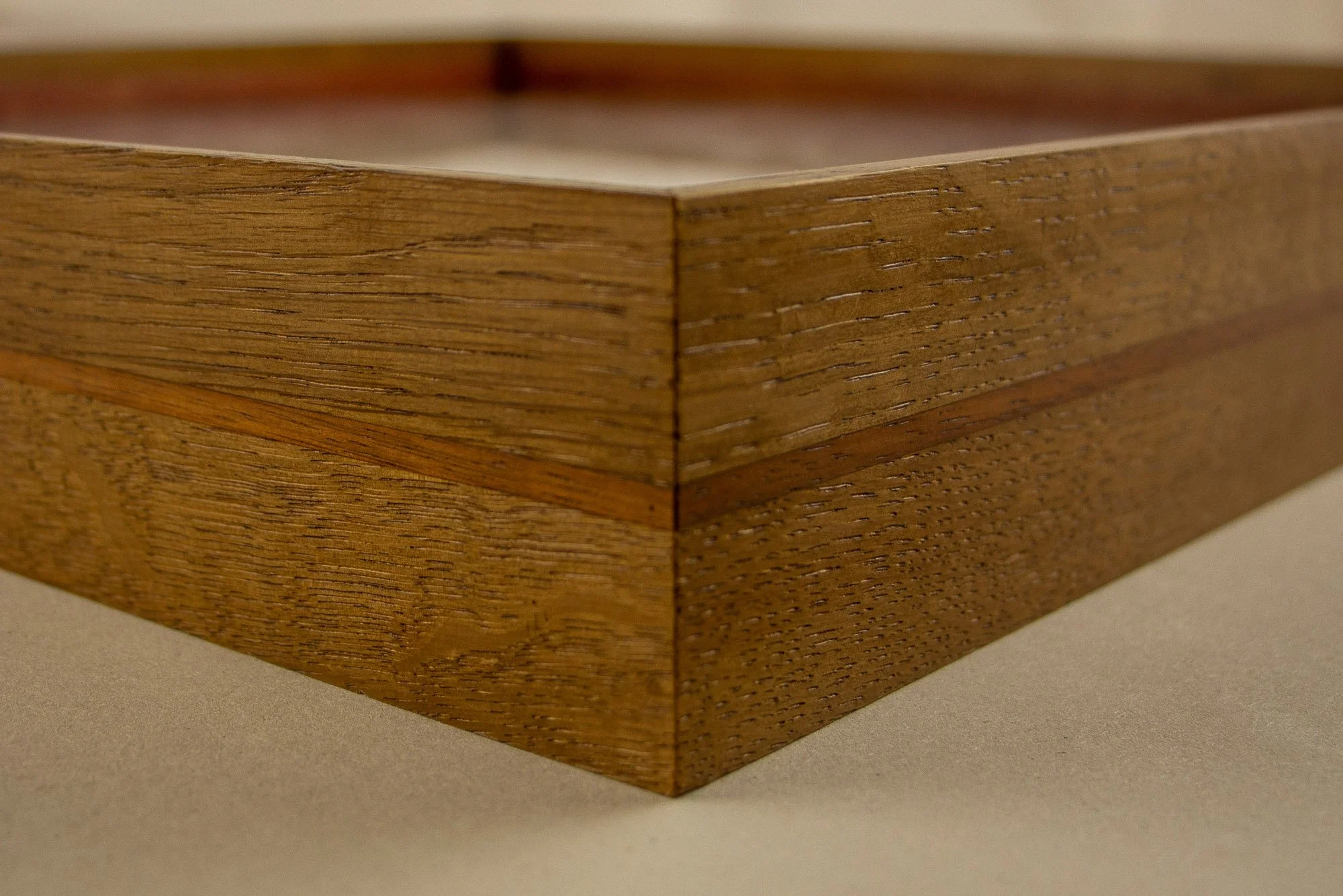 Veiled Alchemist 001 frame detail: close-up of the mitered corner, highlighting the precise join, the fine grain of the wood, and the subtle tonal shift between the wider outer body and the darker inner band.