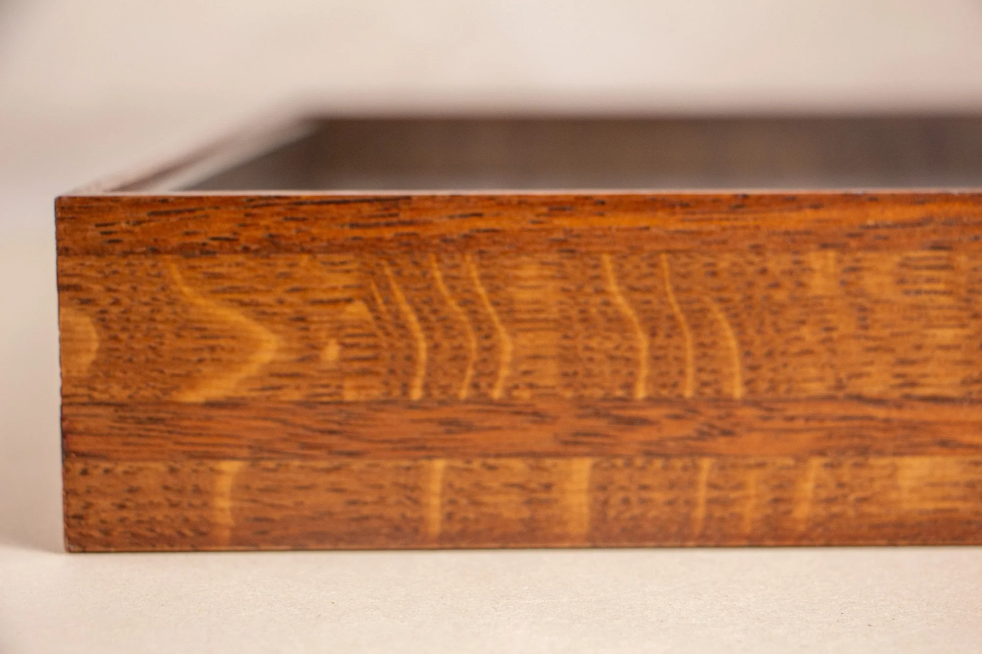 Turbulent Aegis 001 frame detail: side close-up of the handcrafted layered frame, showing the warm cappuccino-toned wood grain and the quiet depth of the construction.