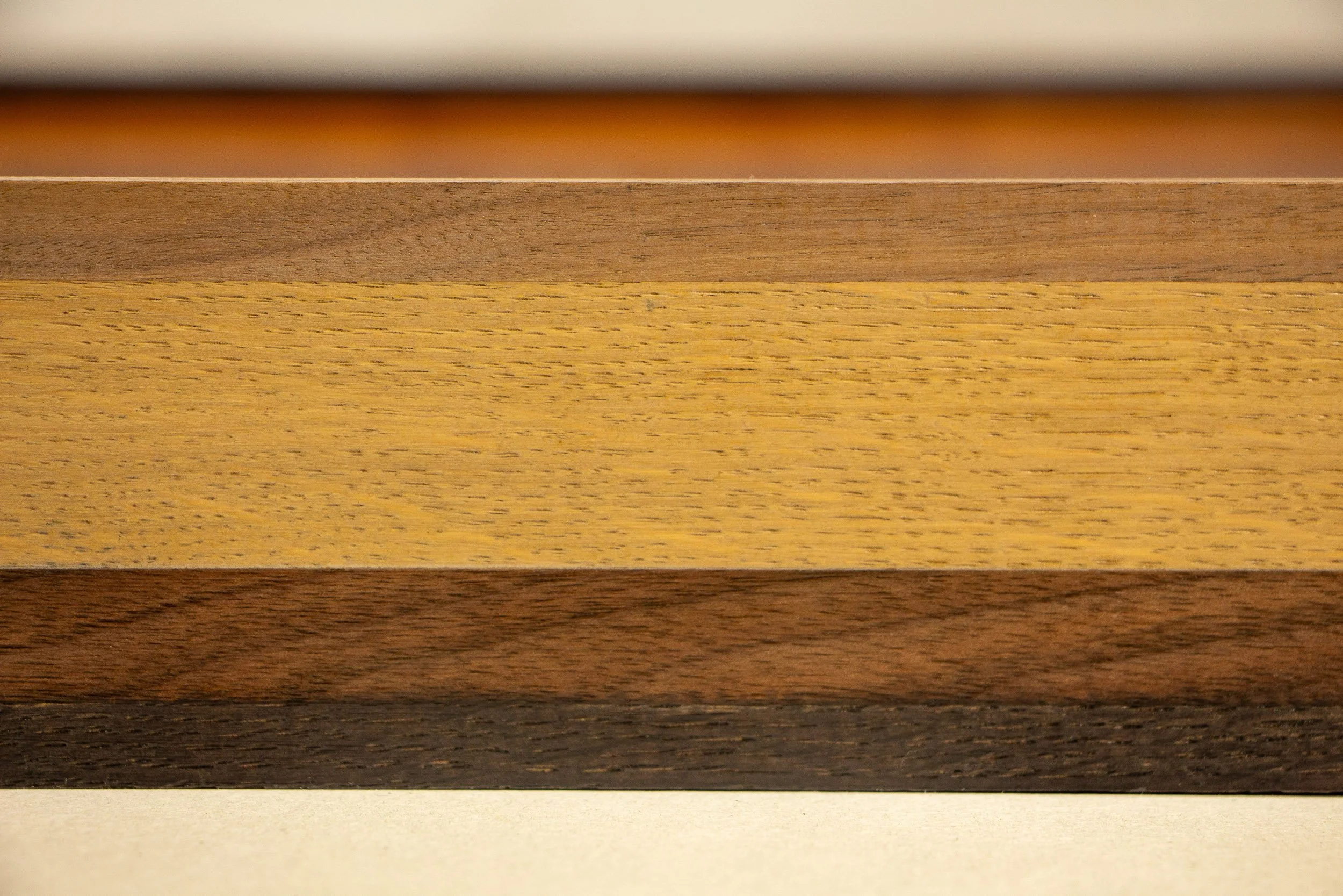 Mêlée of Discovery 005 frame detail: frontal crop of the upper frame edge, showing the clean linear profile and the pale central wood band.