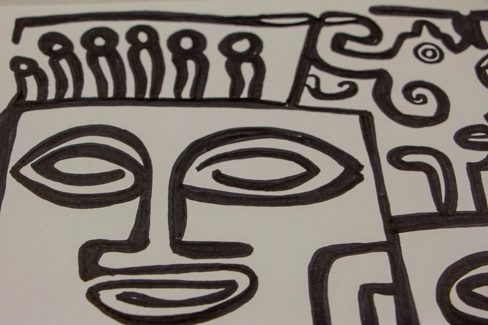 Veiled Alchemist 002 detail: close-up of adjoining forms including a profile with spiral cheek, a crowned or horned figure, and circular eye motifs, revealing the drawing’s shifting dialogue between human and symbolic presence.