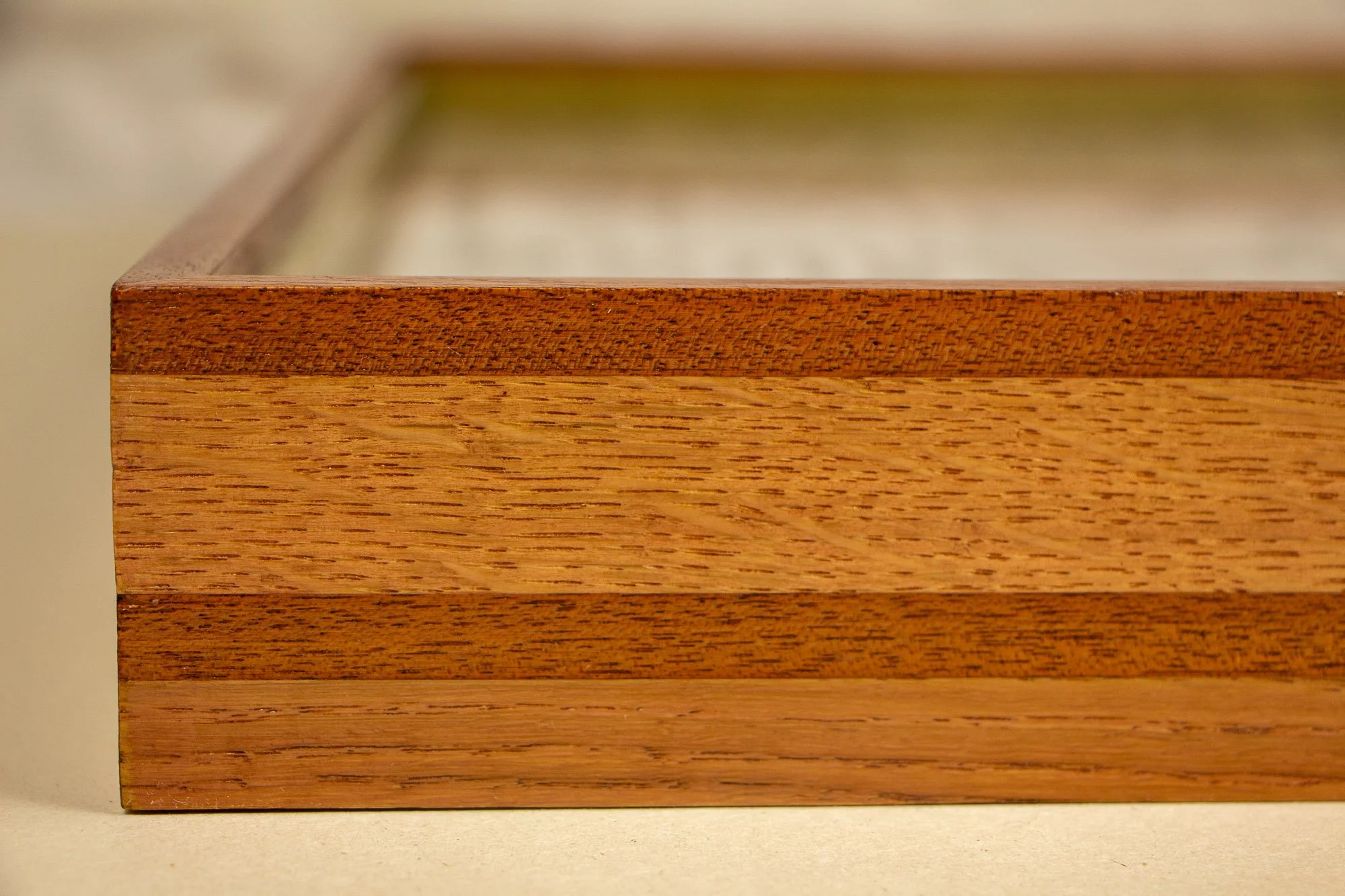 Close-up of a wooden art frame showing the front and side panels with a natural wood finish.