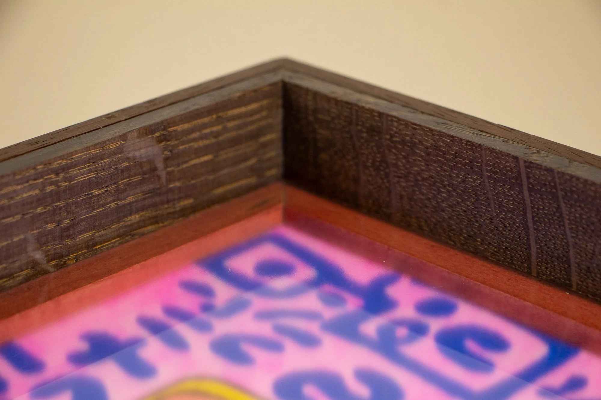 Unseen Signifiers 007 frame detail: close-up of the inner mitered corner, highlighting the dark textured wood grain, the reddish inner liner, and the artwork softly visible beneath the glass. mahogany, oak and beech wood.