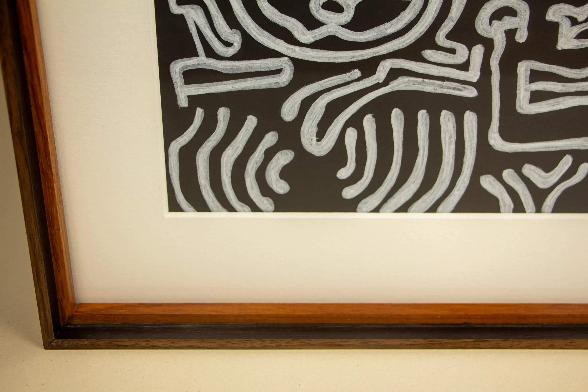 Mêlée of Discovery 003 frame: lower left front detail with the white mount, warm inner edge, and the artwork’s white linework entering the composition.