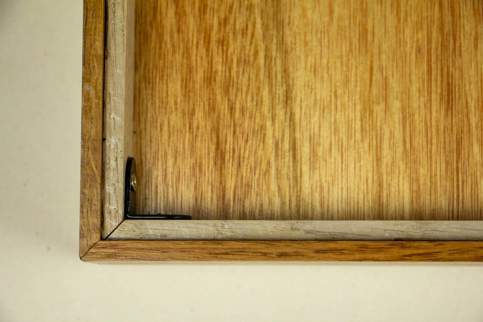 Golden Nostalgia 003 frame: rear corner interior, L-bracket and pale inner liner; oak rabbet with the mahogany band visible