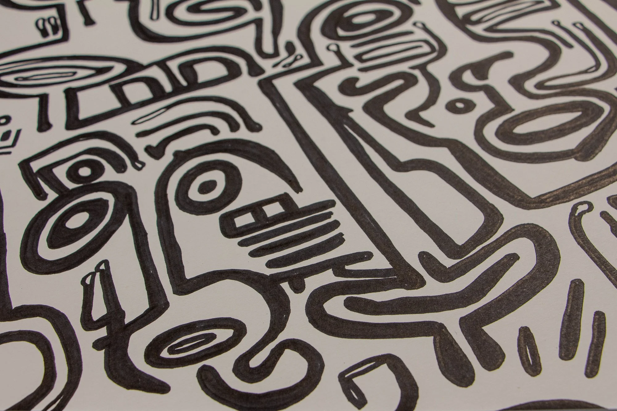 Veiled Alchemist 001 detail: close-up of clustered faces with crown-like marks, spiral eyes, and elongated profiles, revealing the drawing’s layered dialogue between severity, softness, and transformation.