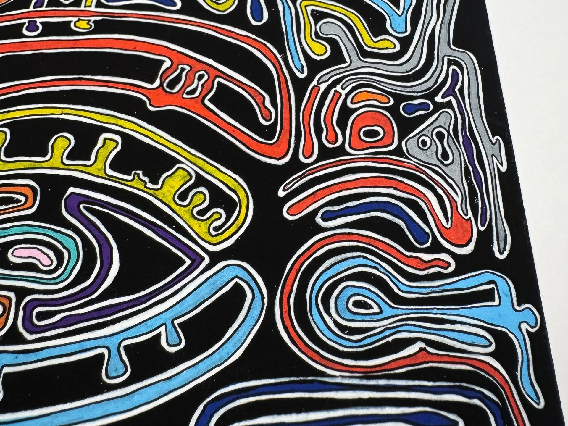 Lower left detail of the composition, showing border motifs and facial line fragments in blue, yellow, pink, orange, red, violet, and grey, set against the black surface near the edge of the paper.