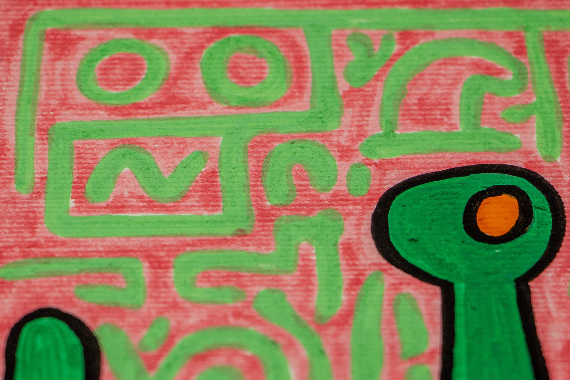Unseen Signifiers 001 detail: close-up of the pink background and green symbols along the edge of the blue face, with two small colored dots inside a green curved form.