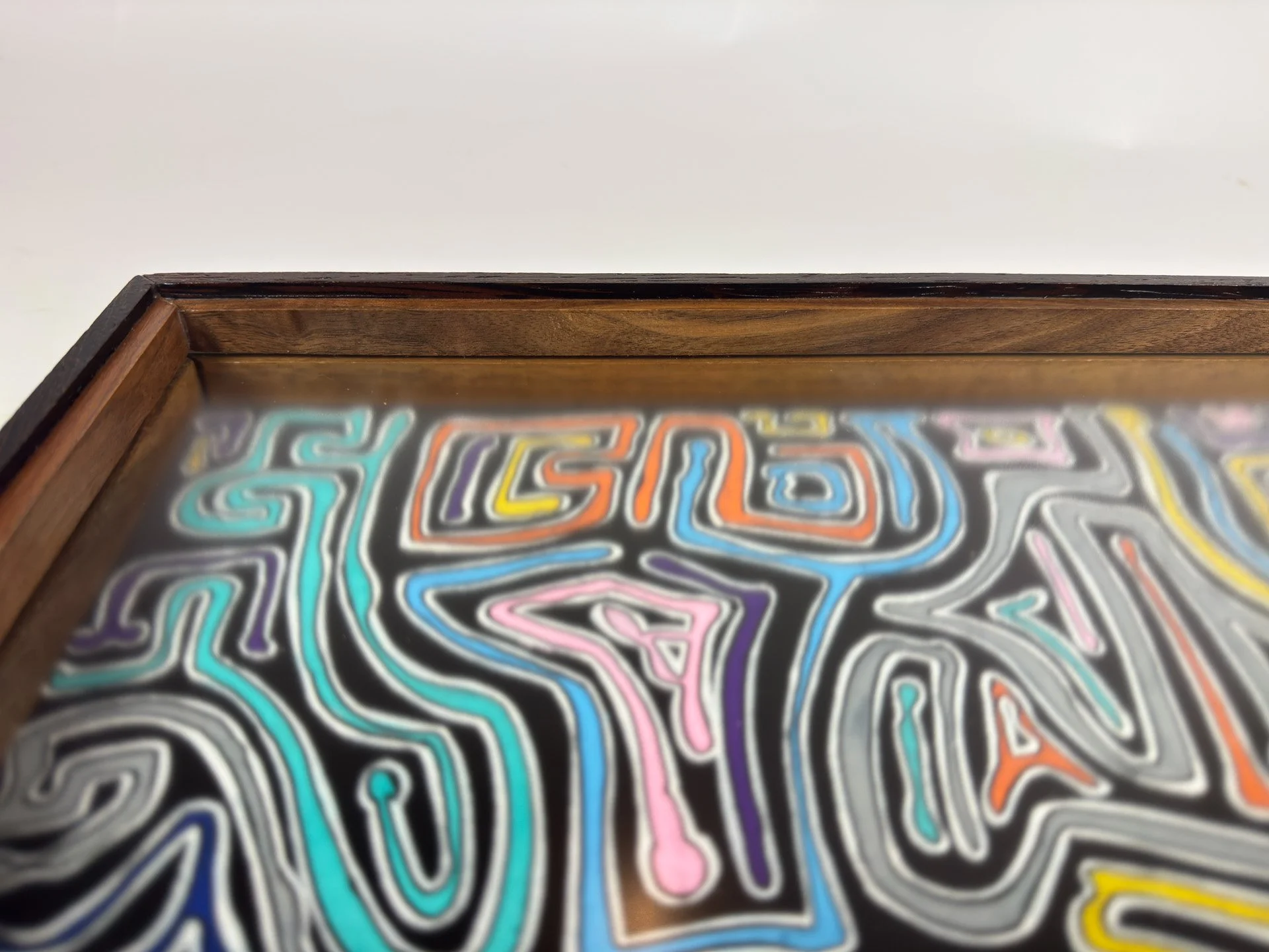 Side-angle close-up of the frame, emphasizing the long dark upper edge, warm oak body, and inward-pulling walnut lip, creating a structure that feels grounded, warm, and precise.