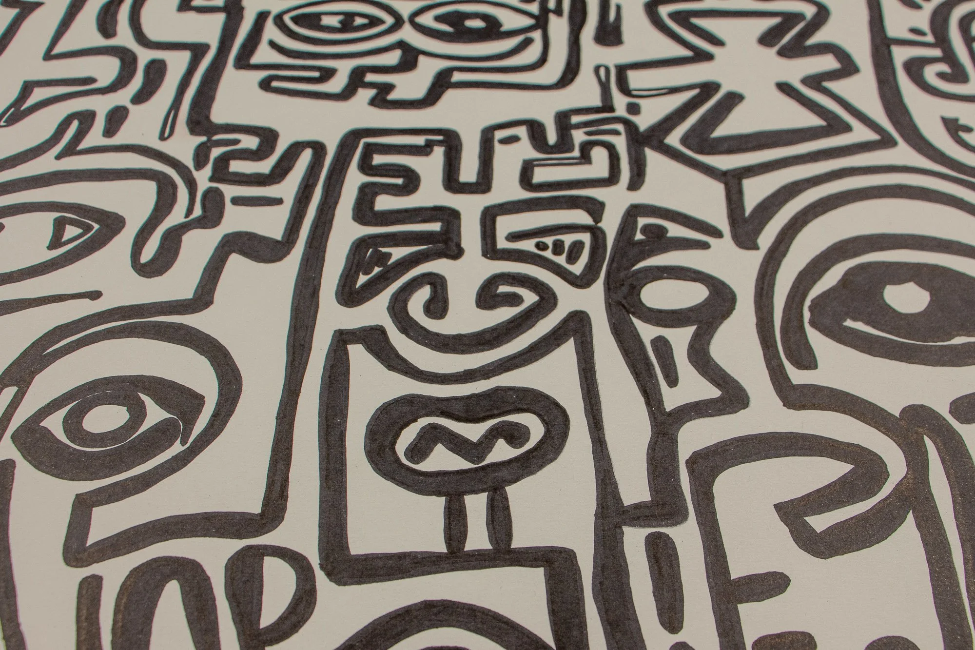 Elusive Cocoon 003 detail: close-up of the upper central composition, focusing on the narrow rectangular mask-like figure with angular brows, a spiral cheek mark, and a small oval mouth, flanked by larger eye motifs and stepped signs.