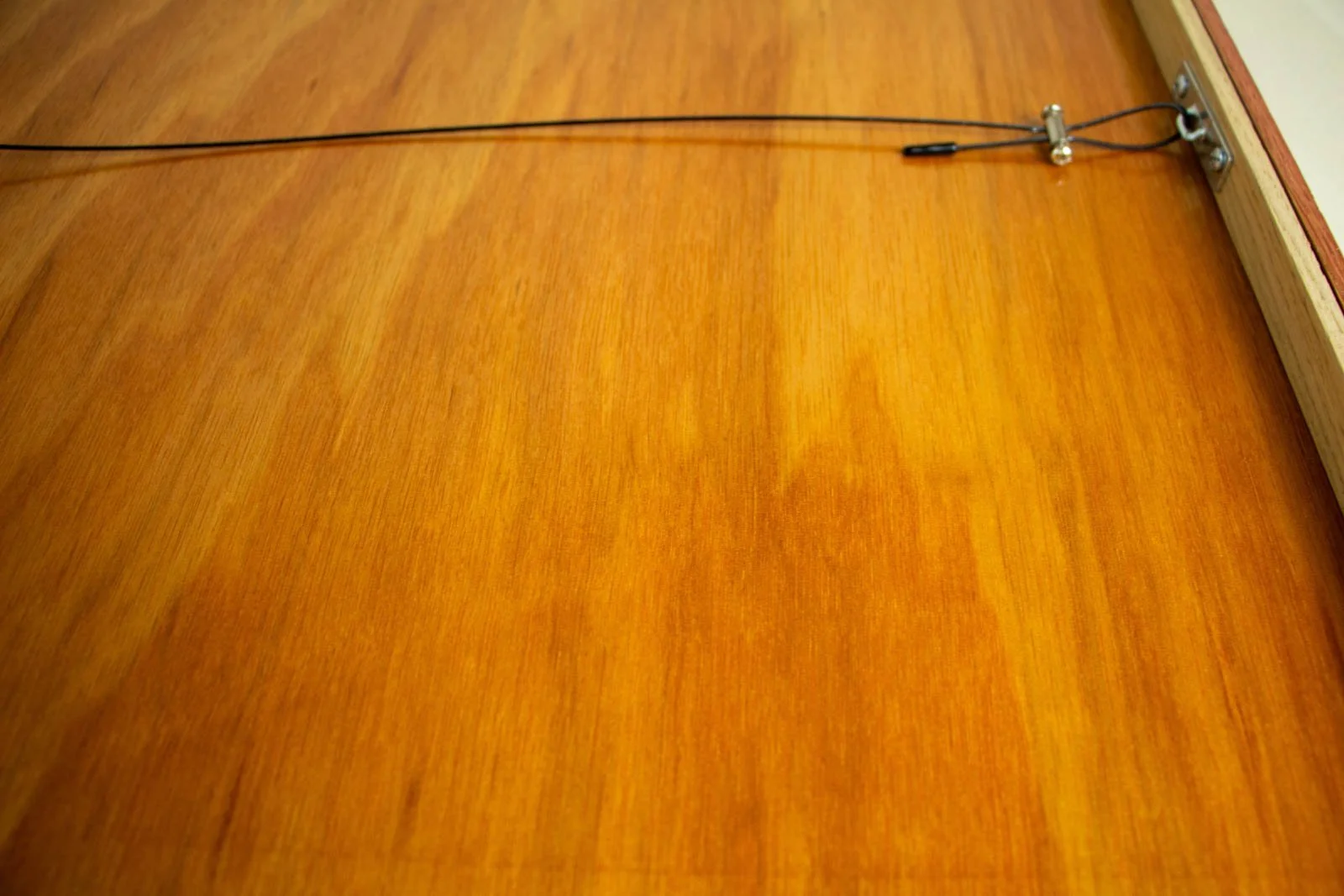 Silence’s Caesura 001 frame: backboard, honey-toned panel with wired hanging hardware anchored at the rail