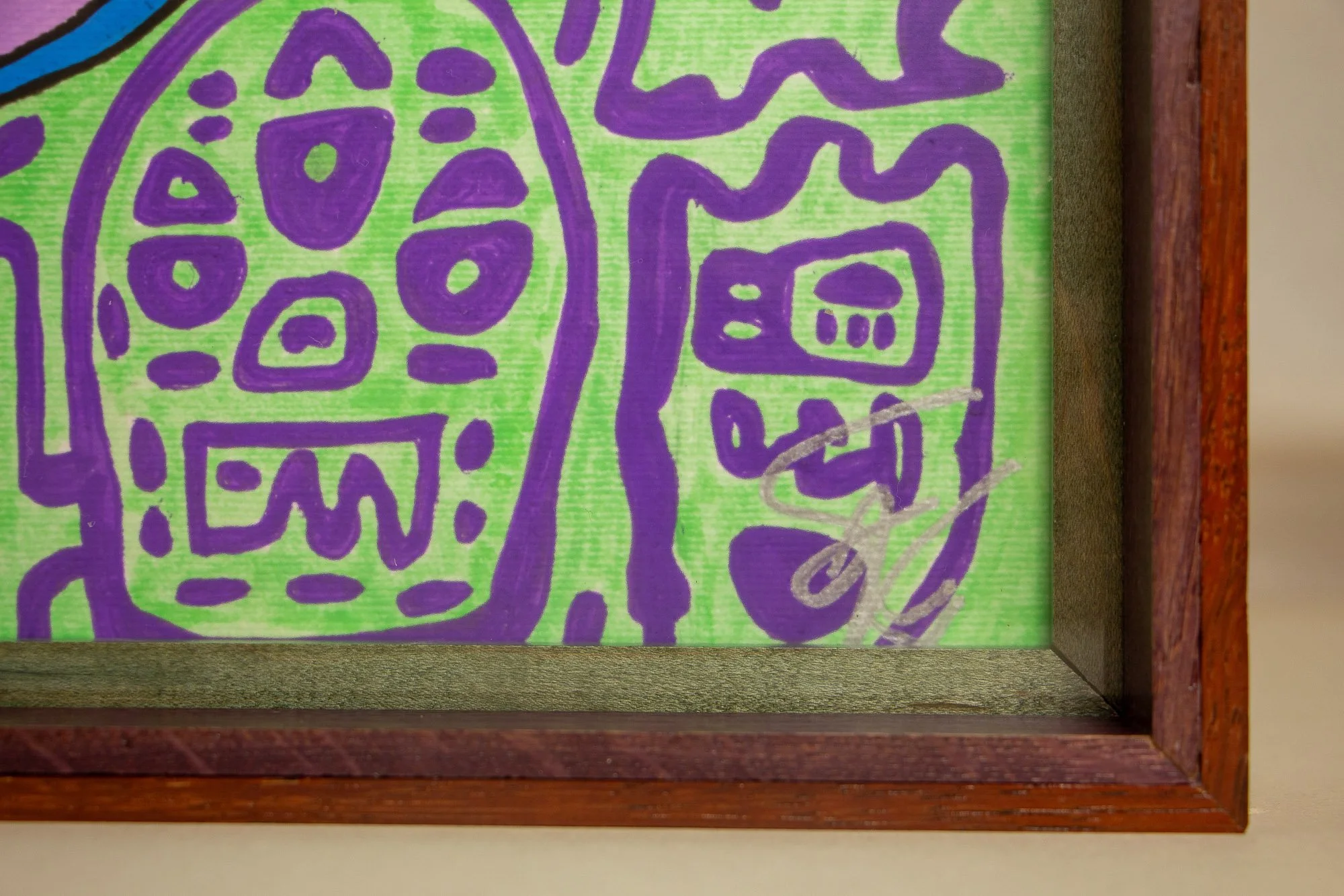 Unseen Signifiers 005 frame detail: lower-right corner detail of the framed work, showing the silver signature on the lime-green ground, bordered by the olive-green inner reveal and the reddish-brown outer frame. mahogany, oak and beech wood.