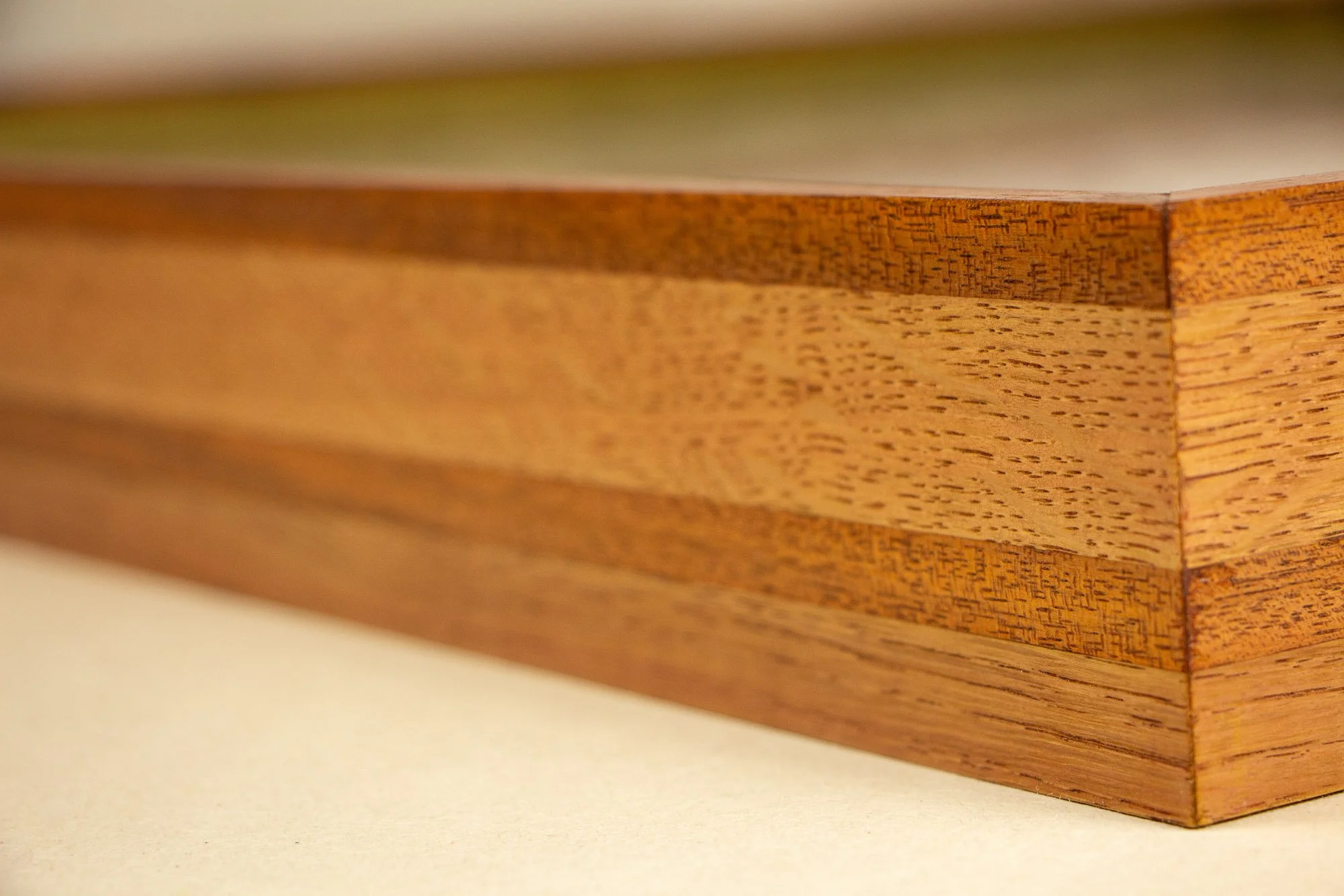 Resonant Syntax 001 frame: mitered corner detail of the frame, showing the layered construction, color sequencing, and carefully aligned wood grain across the joint