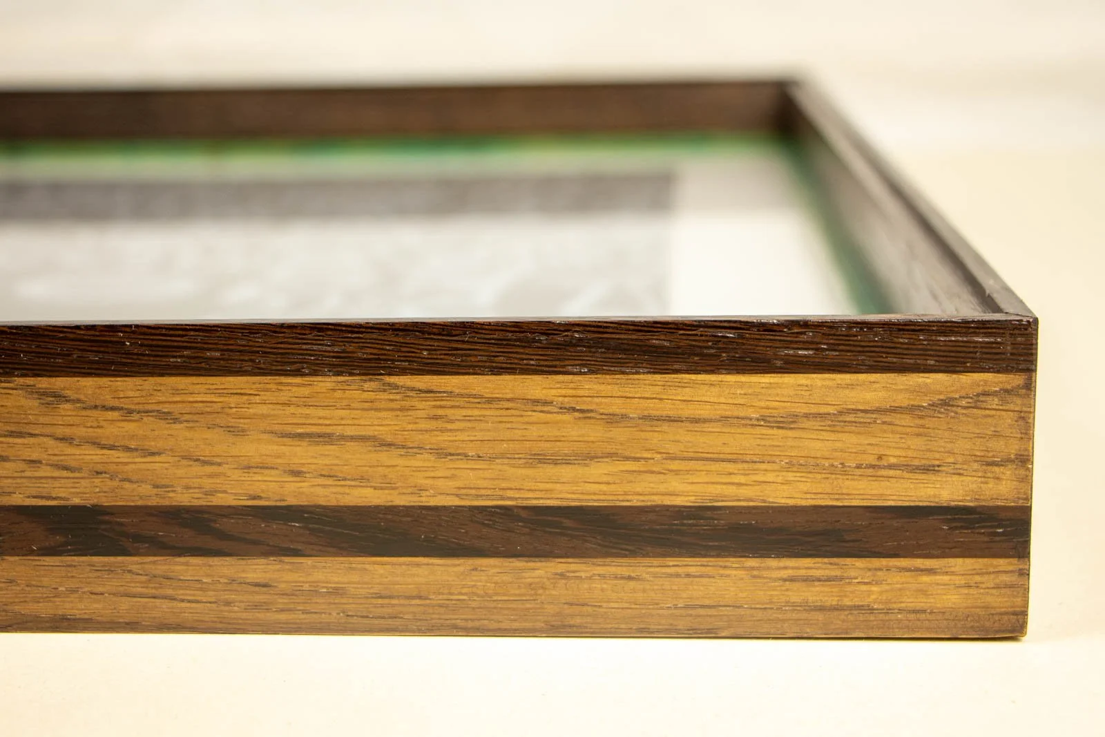 Synaptic Mythos 004 frame: long side profile, upper wengé lip and lower wengé rail aligned; warm ash-stained oak field