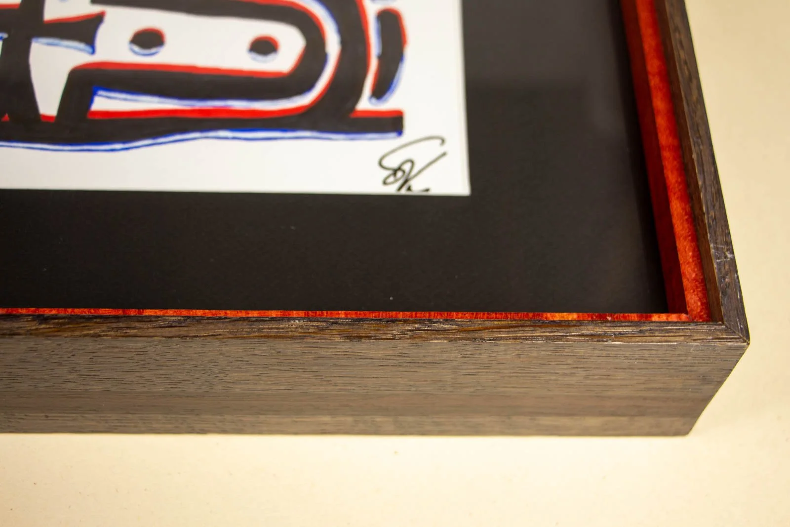 Flux Impromptu 002 frame: rear corner interior, Granada-red perimeter batten with black L-bracket; pale wood back panel, crisp rabbet