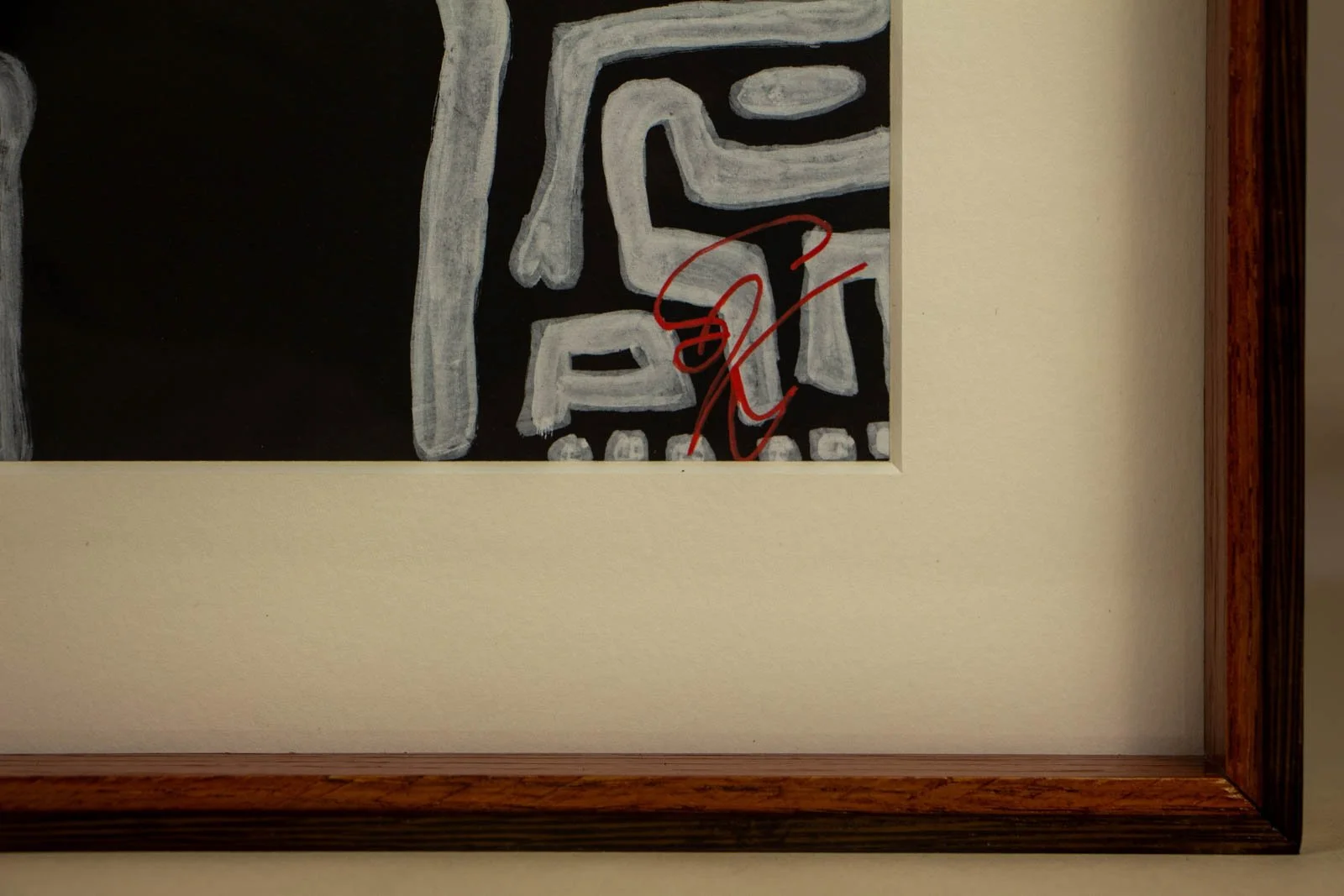 Metamorphic Entwining 002 frame: lower-right sight, artist’s red signature behind glass; beveled mat meets badi liner; wengé inner lip along the bottom rail