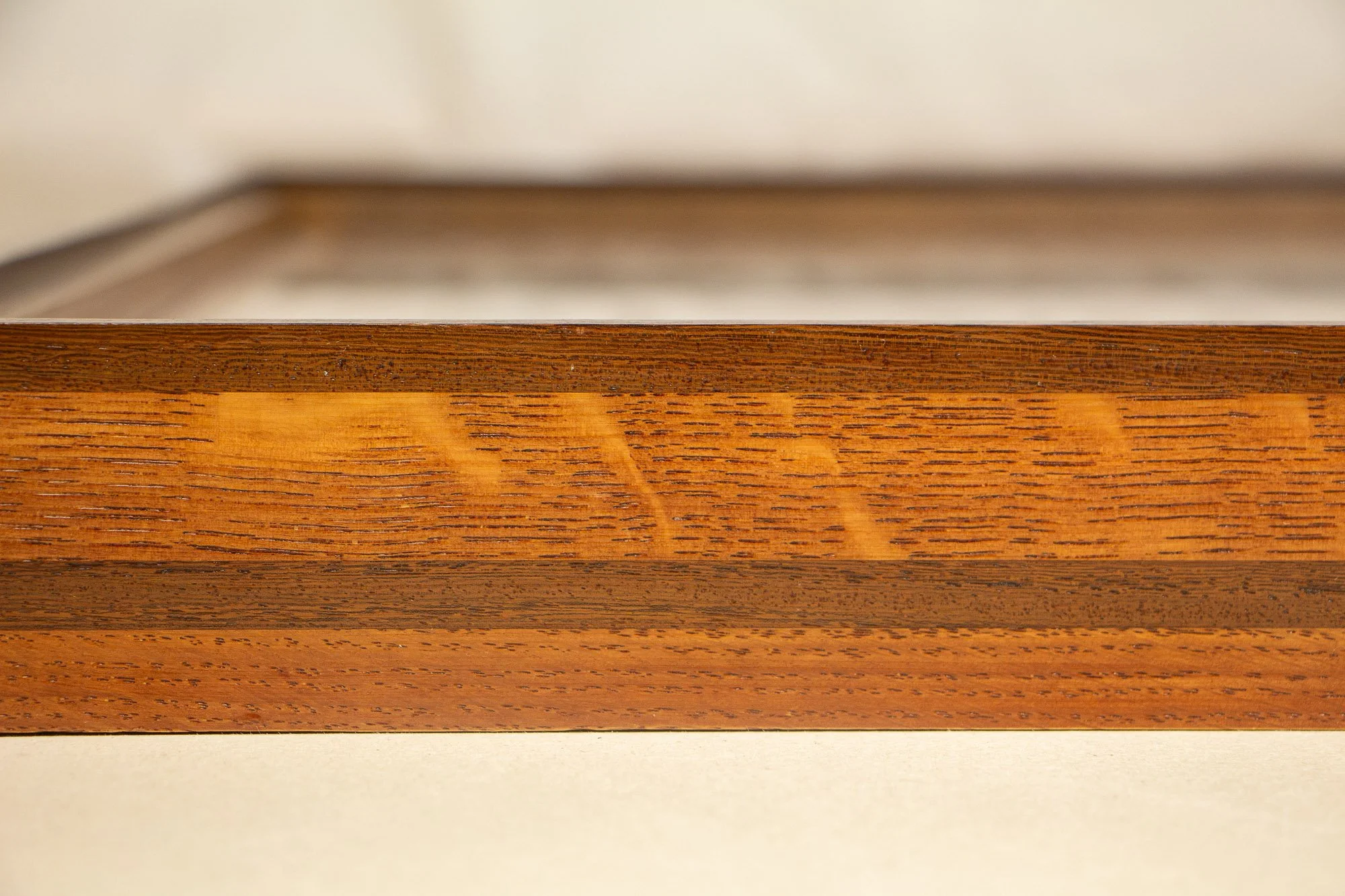 Elusive Cocoon 001 frame: frontal close-up of the frame profile, with dark palisander edging, a light ash-toned middle band, visible grain variation, and a clean satin finish.