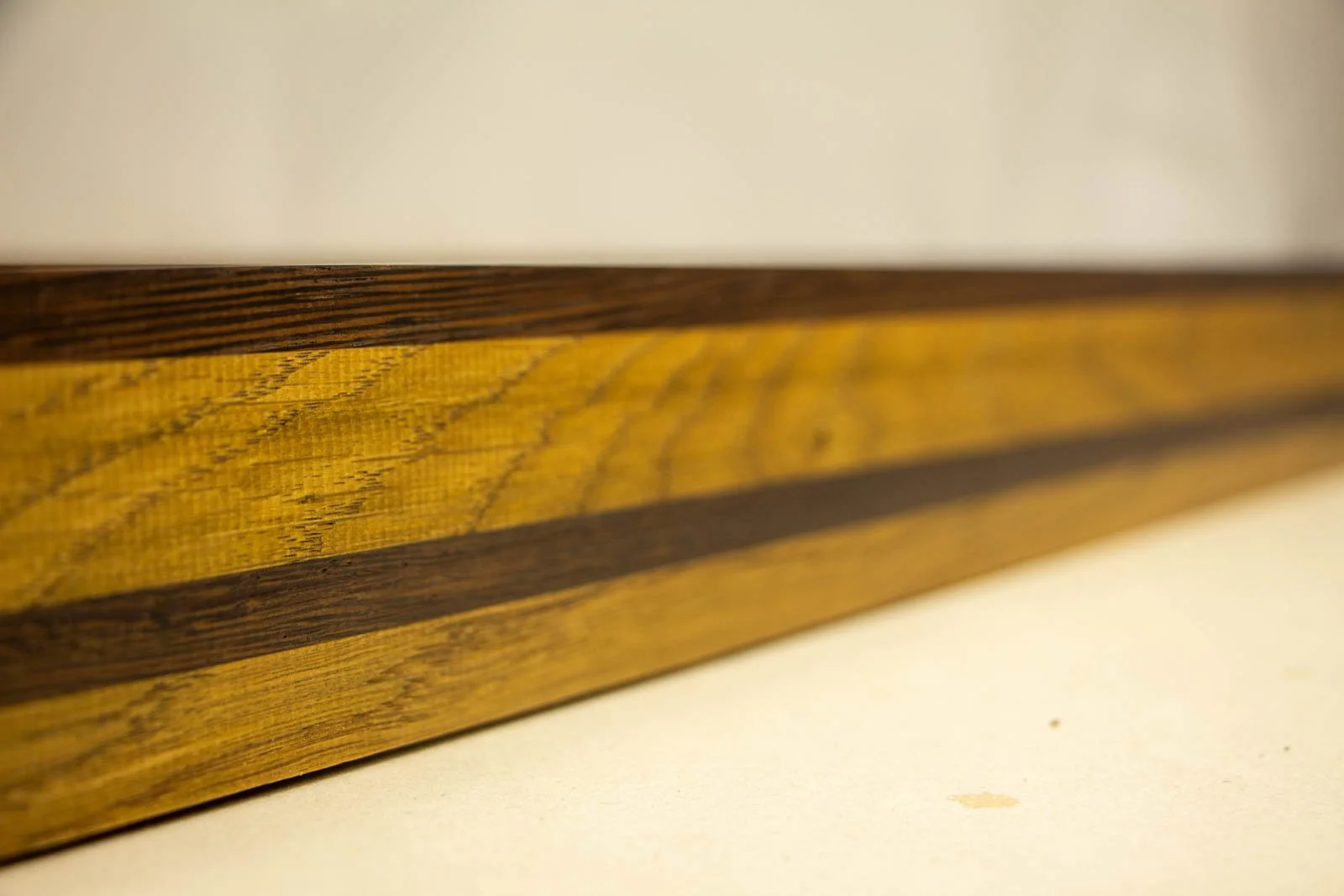 Metamorphic Entwining 004 frame: oak frame with slim wengé cap and a continuous wengé band; olive-honey grain; glass set flush