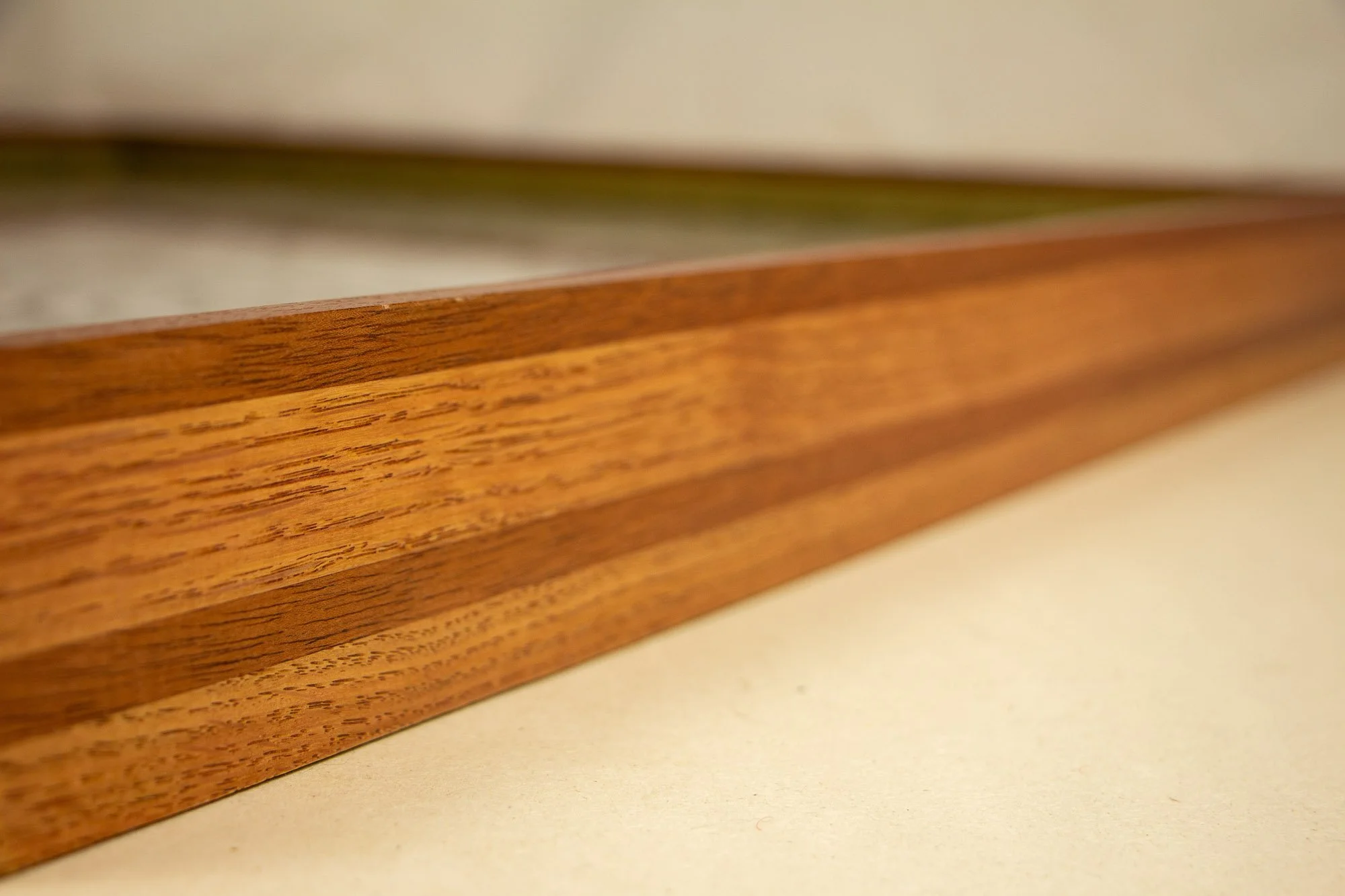 Resonant Syntax 001 frame: angled side view of the layered frame construction, emphasizing the elongated profile, tonal shifts, and the contrast between mahogany and oak