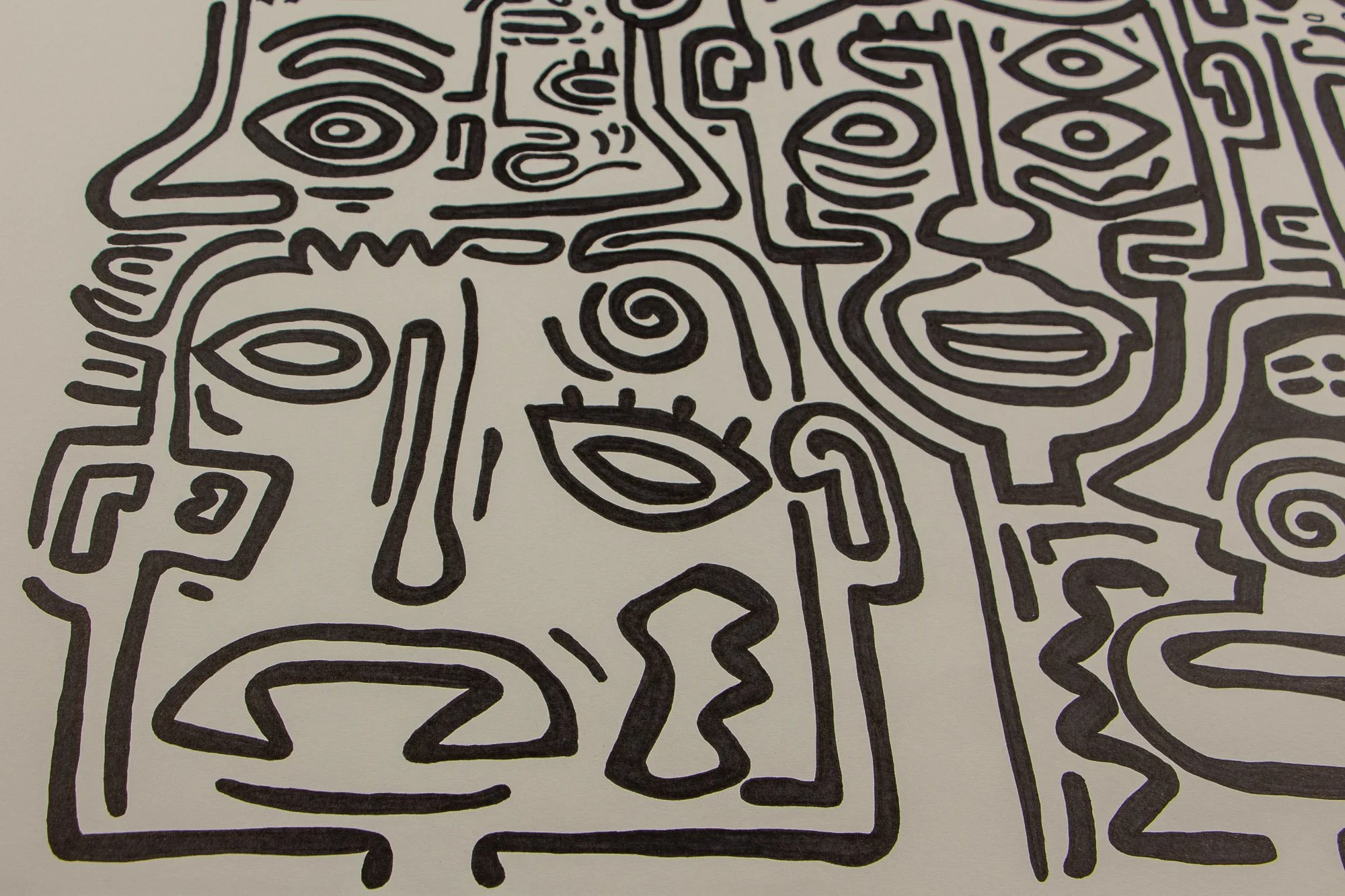 Resonant Syntax 002 detail: frontal close-up of the large lower-left face, with long nose, spiral forehead, eyelashed eye, and broad curved mouth; bold black contours on paper