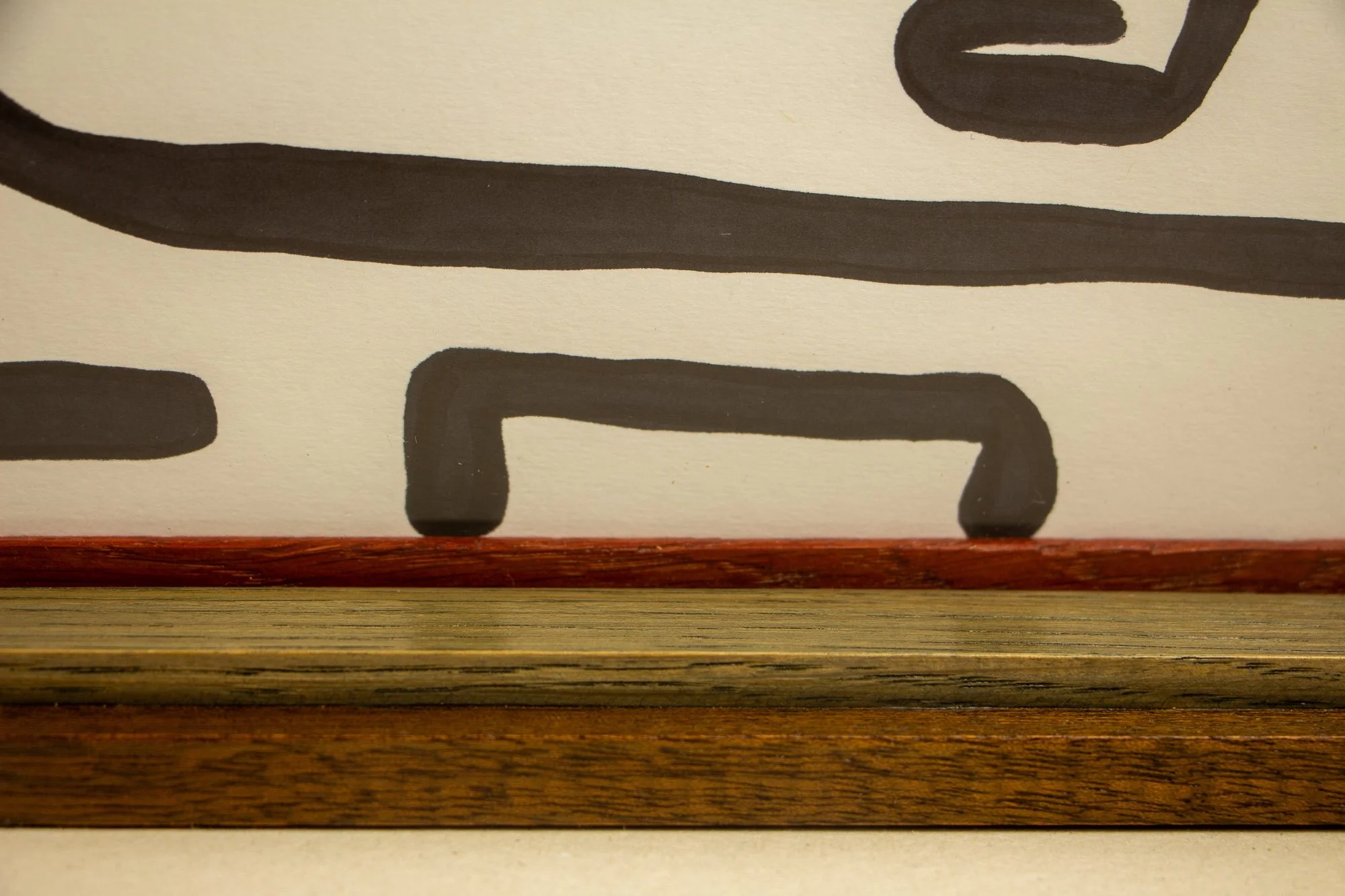 Resonant Syntax 002 frame: lower edge detail of the frame construction, with mahogany outer band, layered oak elements, inner lip, and the artwork surface visible above