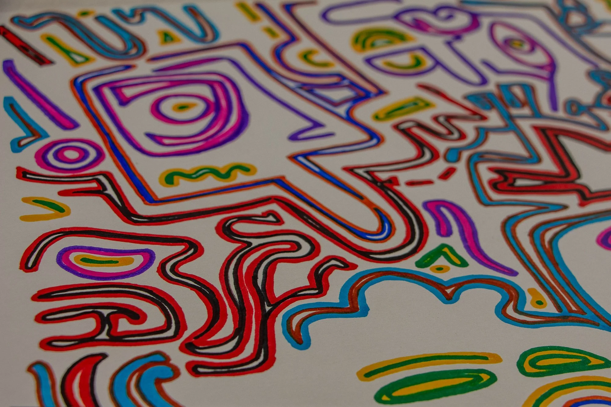 Eclipsing Gravitas 001 detail: angled close-up of layered abstract figures with a pink eye, blue and red contour lines, and curling multicolored forms moving across the white paper surface.