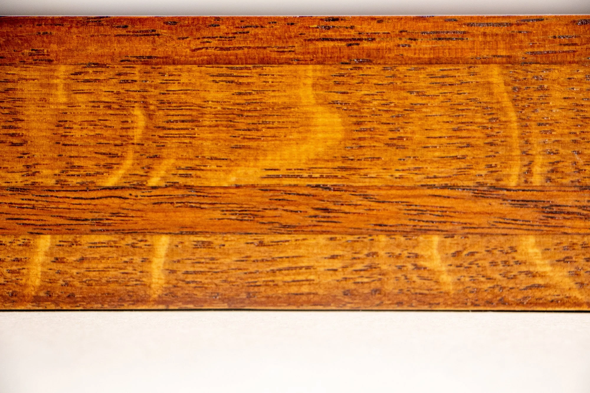 Turbulent Aegis 001 frame detail: close-up of the frame’s wood surface, emphasizing the warm layered grain, tonal transitions, and refined handcrafted finish.