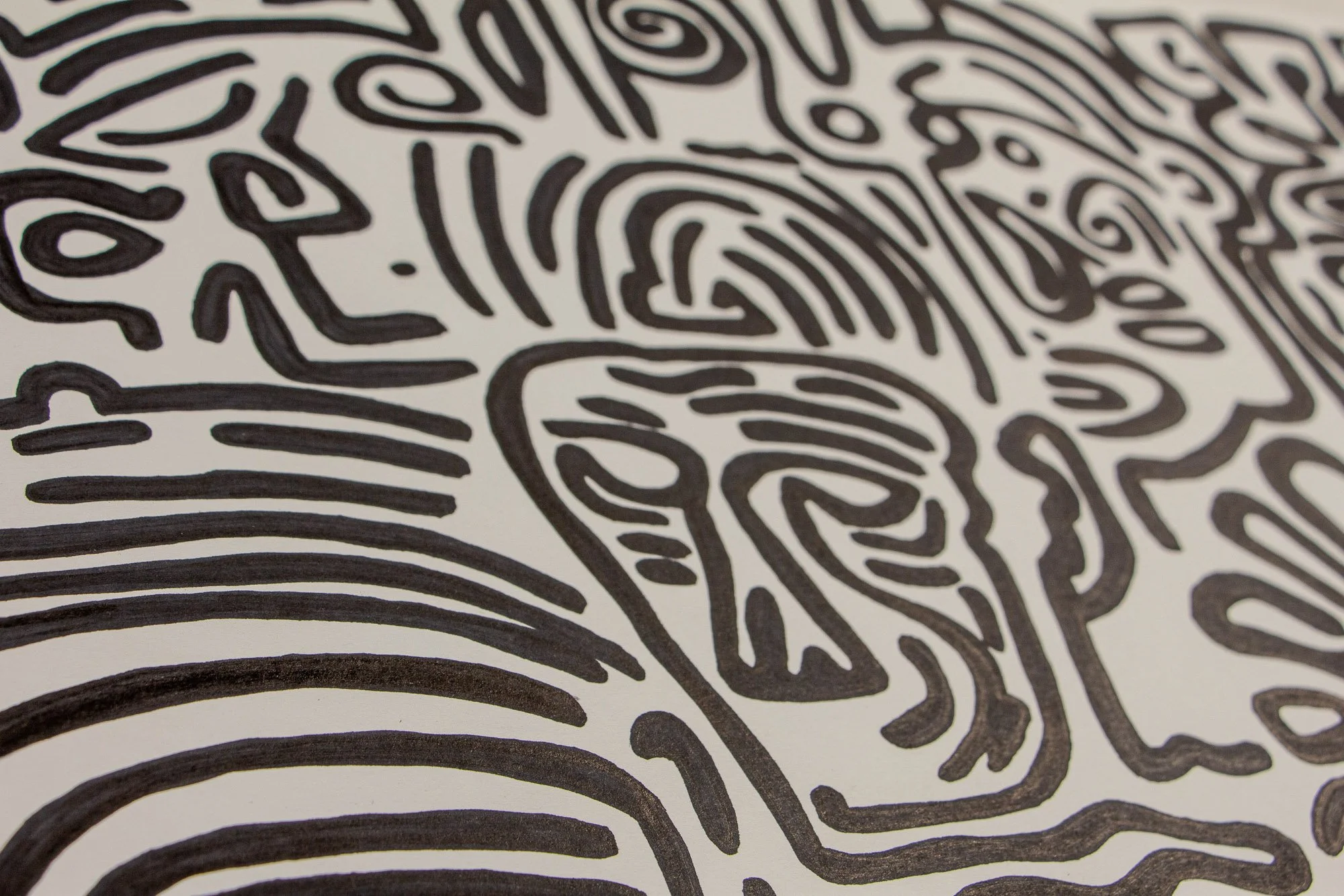 Mêlée of Discovery 002 detail: angled surface view of the composition, showing how looping contours, eyes, and mask-like forms spread across the paper in a continuous shifting field.