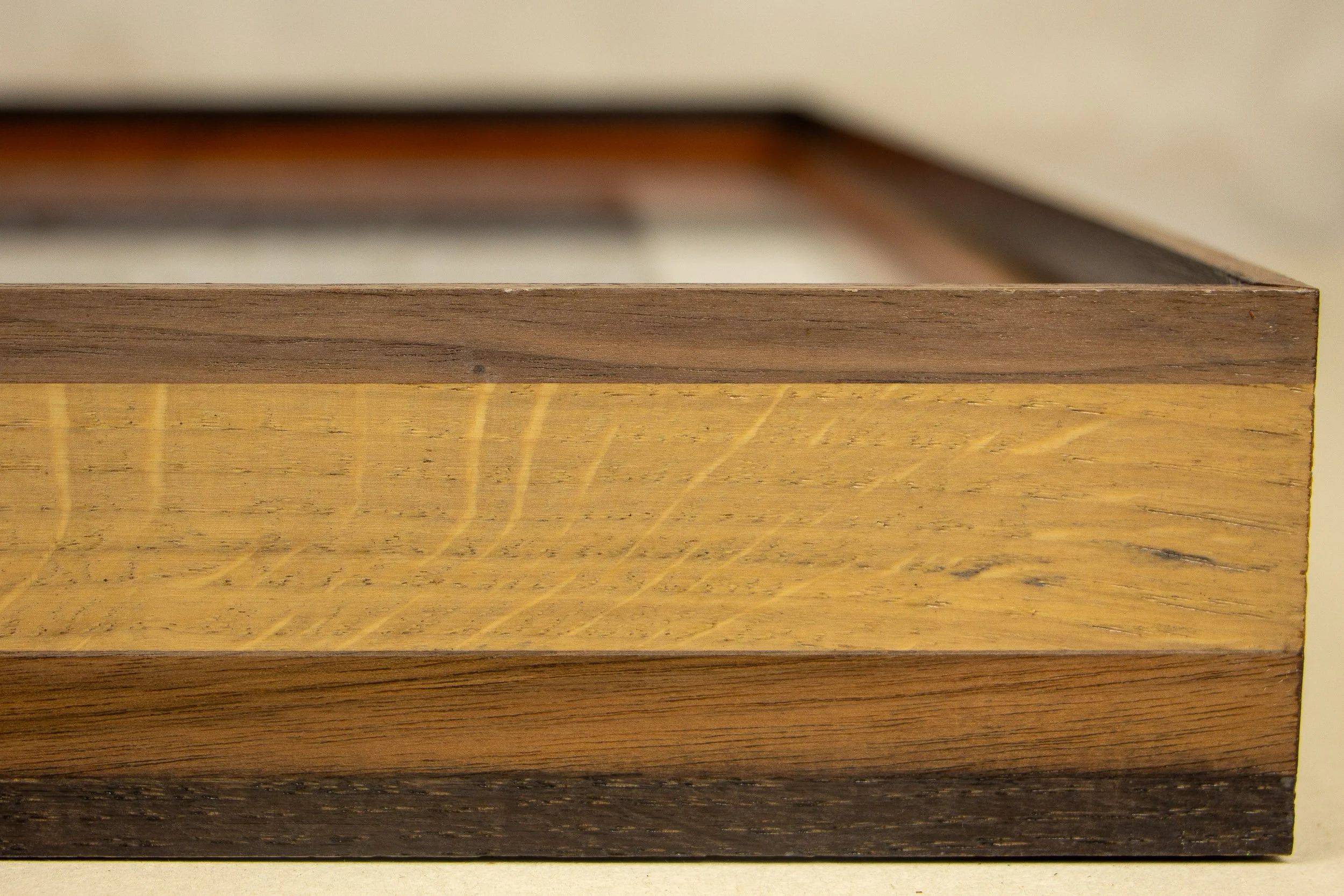 Mêlée of Discovery 003 frame: lower left front detail with the white mount, warm inner edge, and the artwork’s white linework entering the composition.