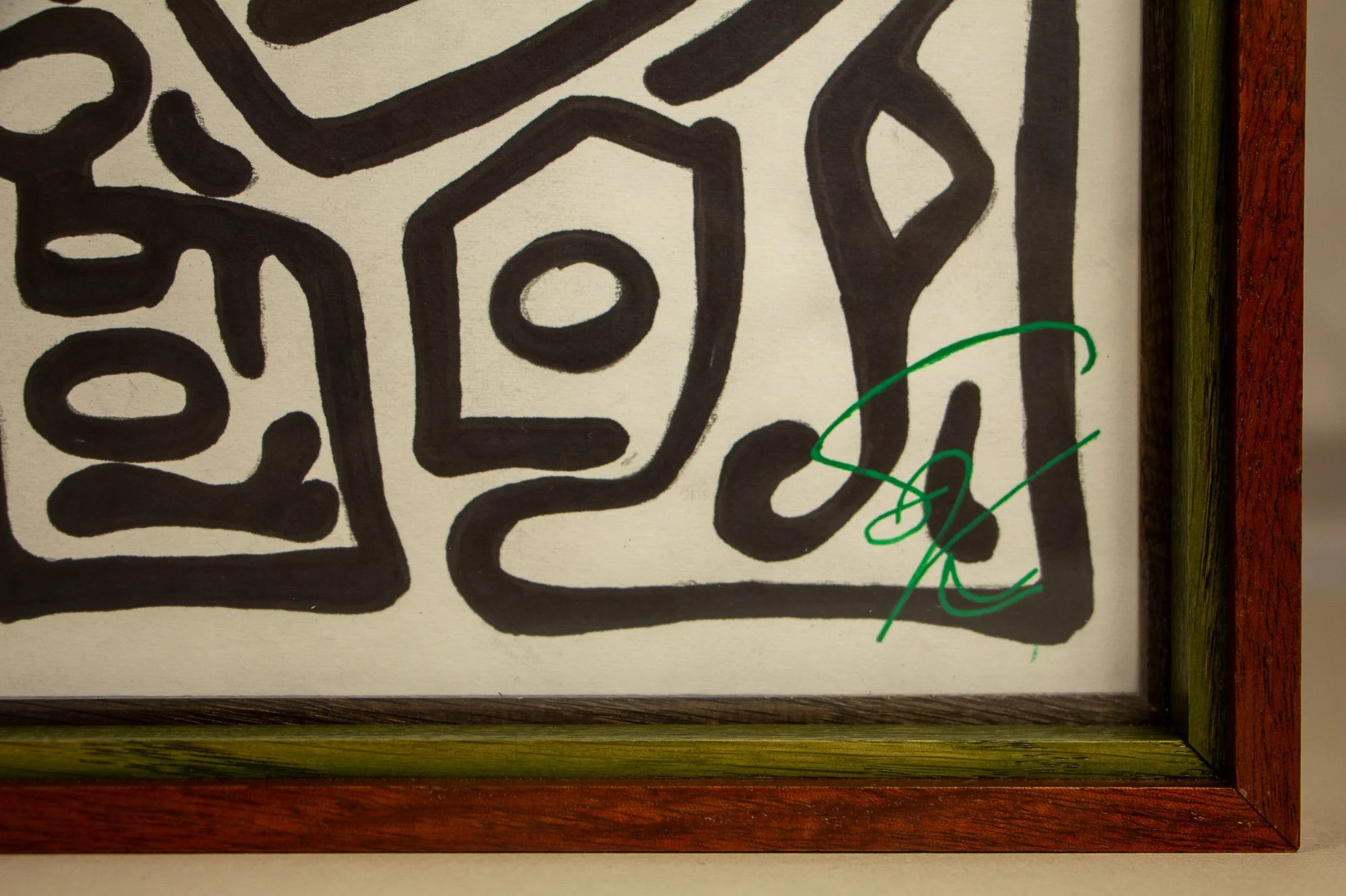 Resonant Syntax 003 frame: upper edge detail with red outer frame, green inner spacer, dark granada lip, and black ink linework visible below the glass