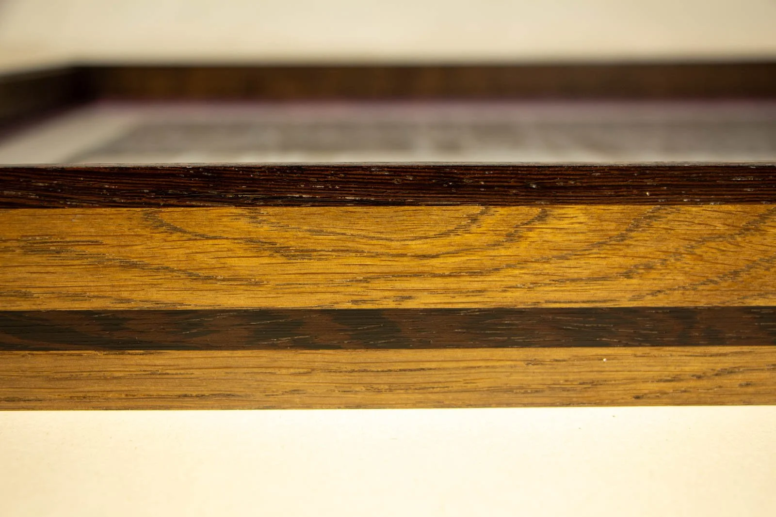 Synaptic Mythos 002 frame: long side elevation, oak field warmed with ash stain; upper wengé lip and lower wengé rail aligned