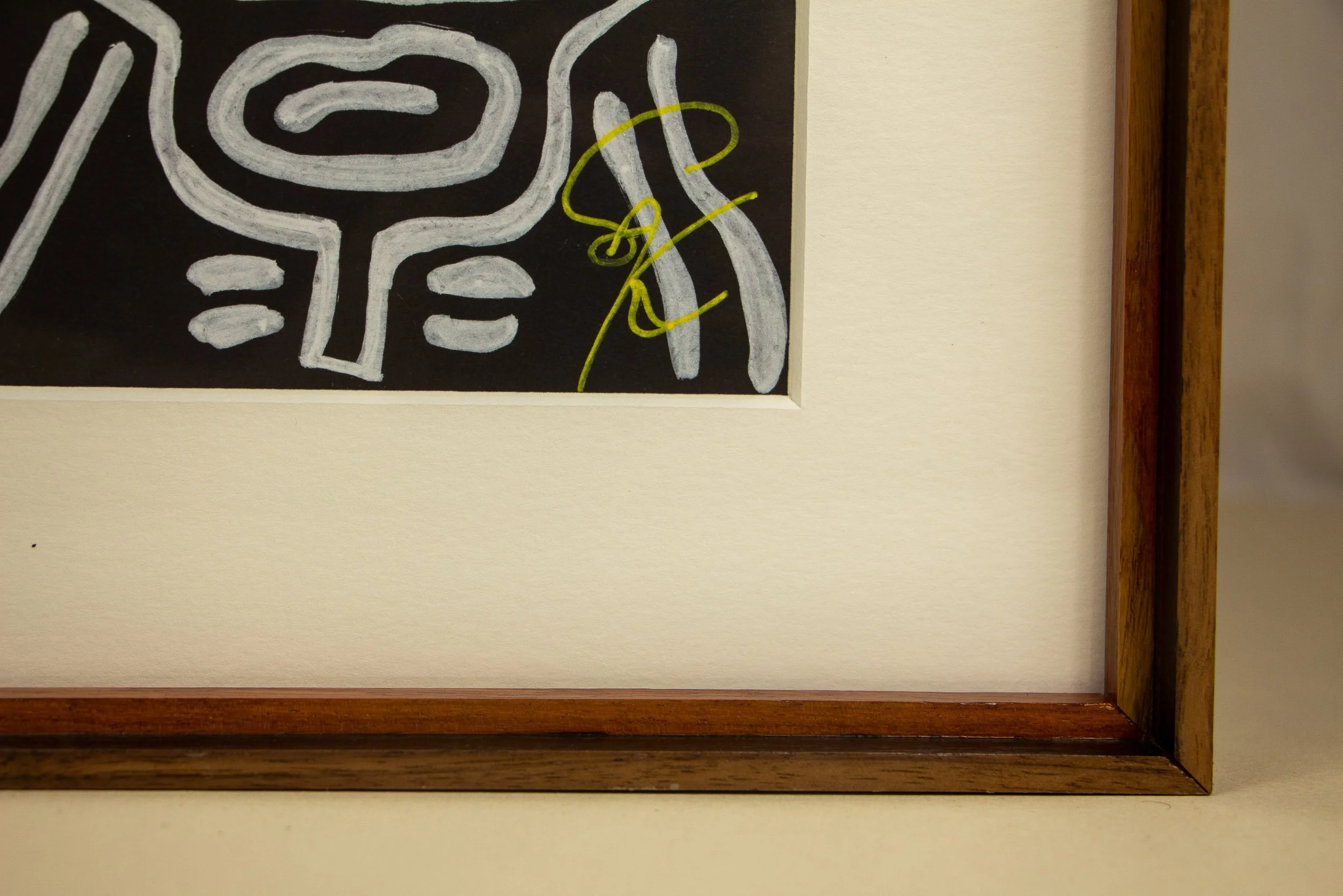 Mêlée of Discovery 003 frame: lower right front detail showing the lime-yellow signature against the dark artwork field, bordered by the mount and layered wooden frame.