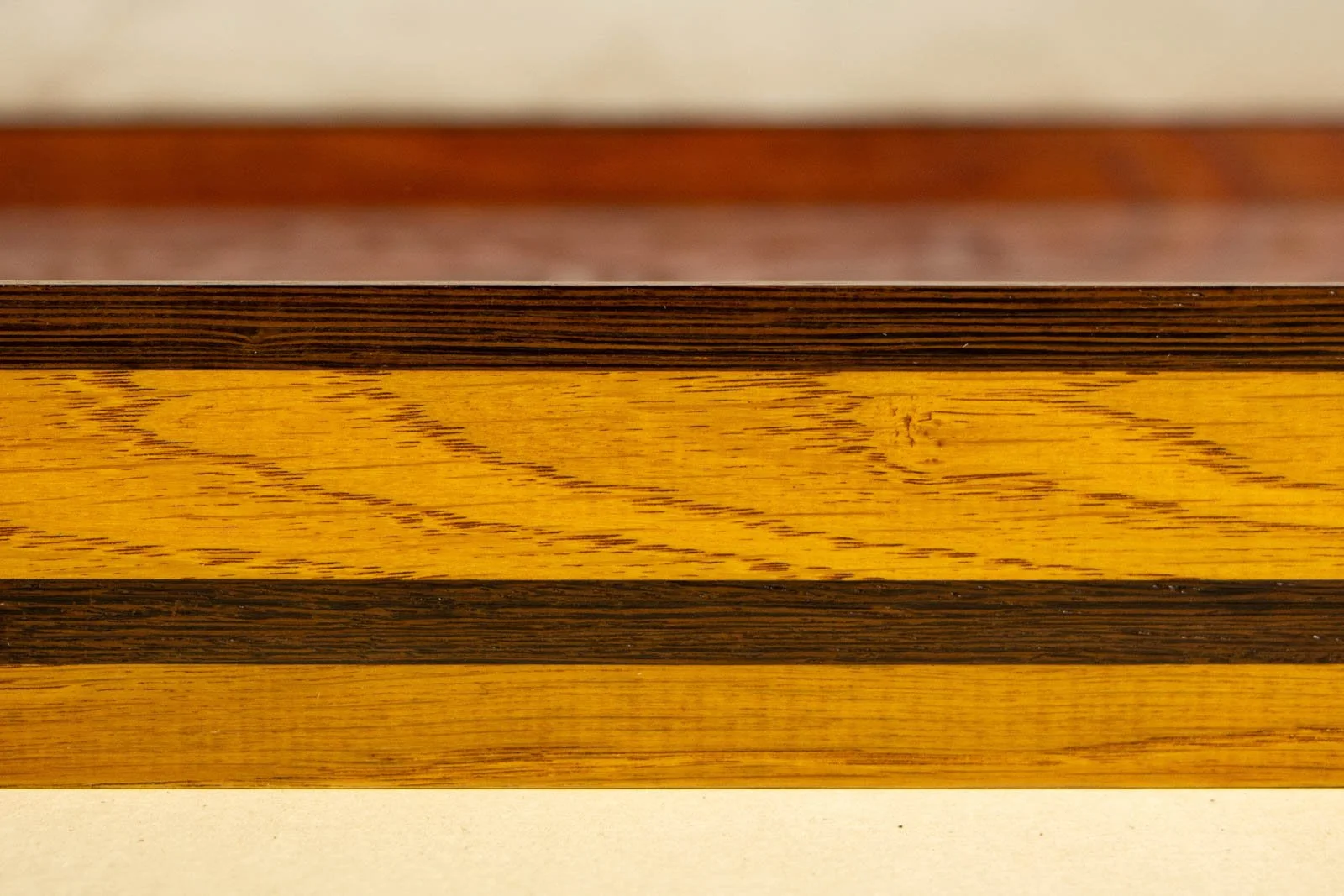 Metamorphic Entwining 002 frame: straight side view showing even oak figure, dark wengé top edge, and lower wengé stripe; smooth lacquer sheen