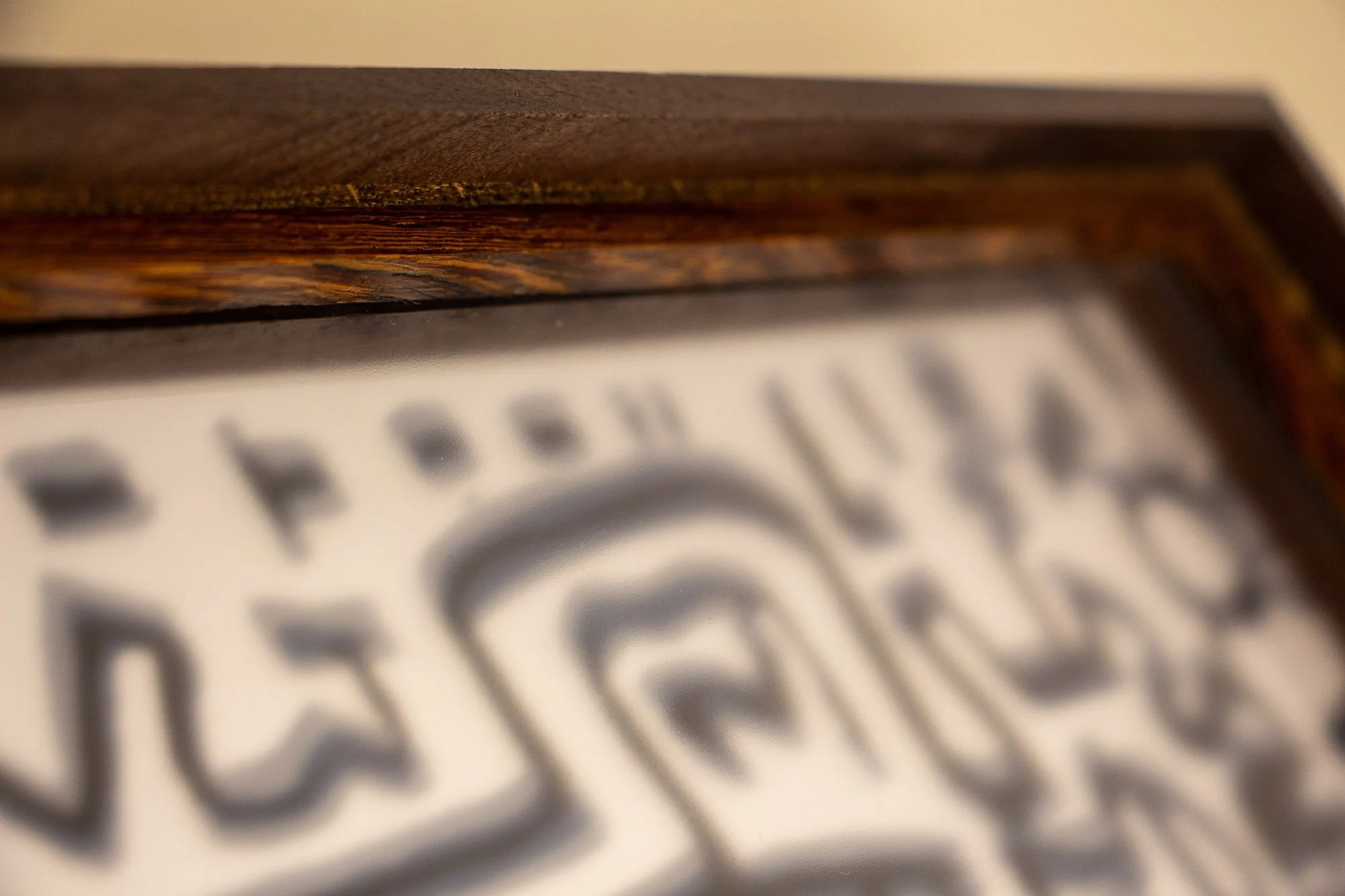 Luminous Parallax 003 frame: straight-on detail of the upper inner edge, where the figured wood lip and slim dark line create a subtle threshold between frame and image.