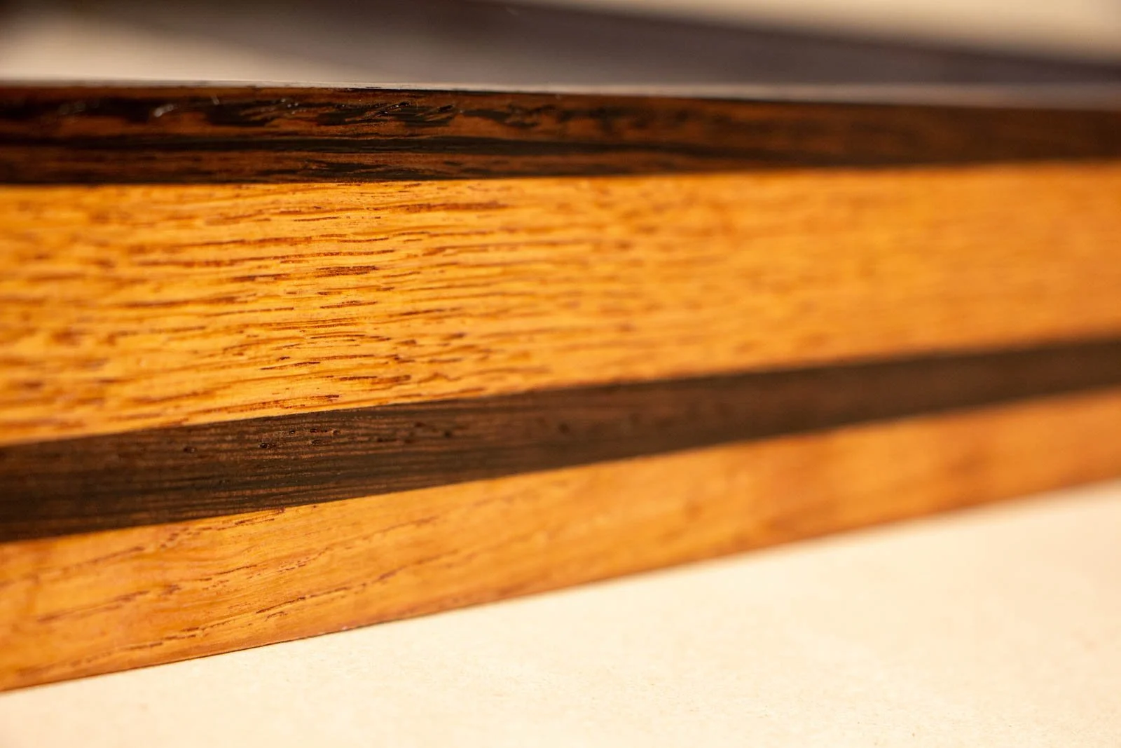 Formless Equation 003 frame: layered oak with dark wengé accents, subtle tool marks, warm satin finish