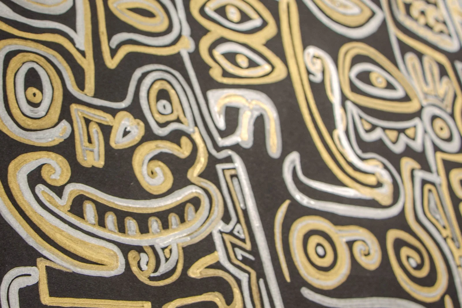 Golden Nostalgia 004 detail: metallic gold/silver on matte black, grinning mask with curled cheek lines and stacked eyes