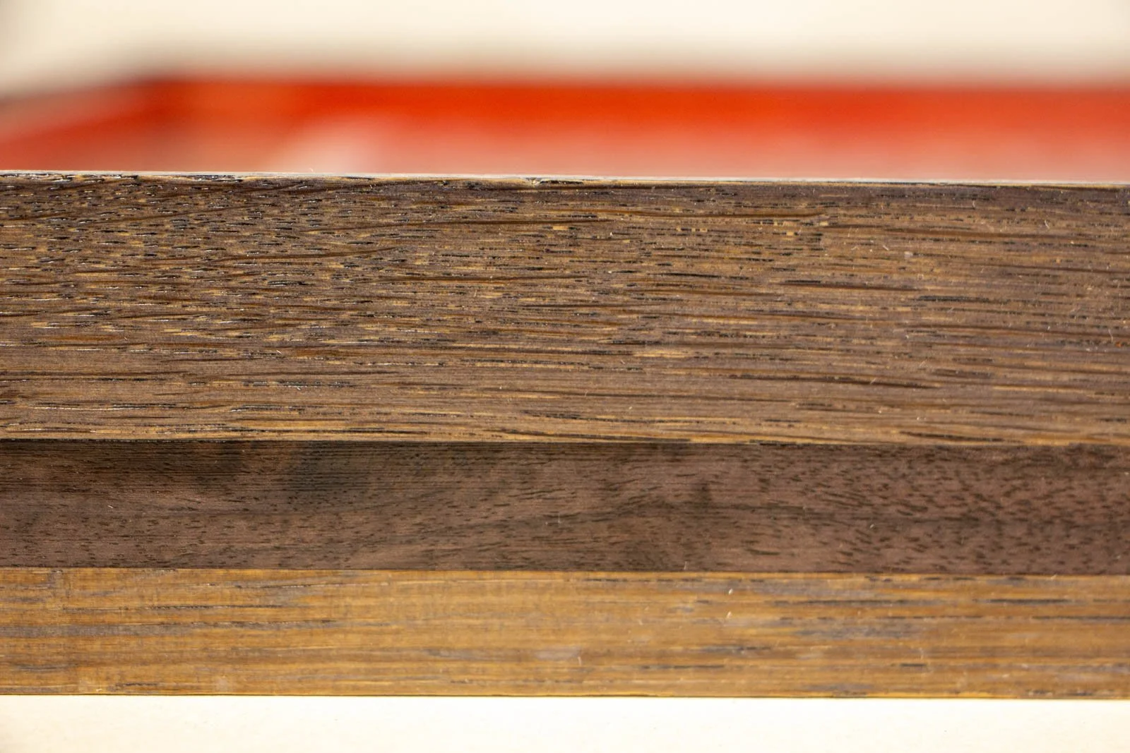 Flux Impromptu 001 frame: side view, grain runs horizontally; walnut accent wraps around; a hint of red from the inner liner in the background